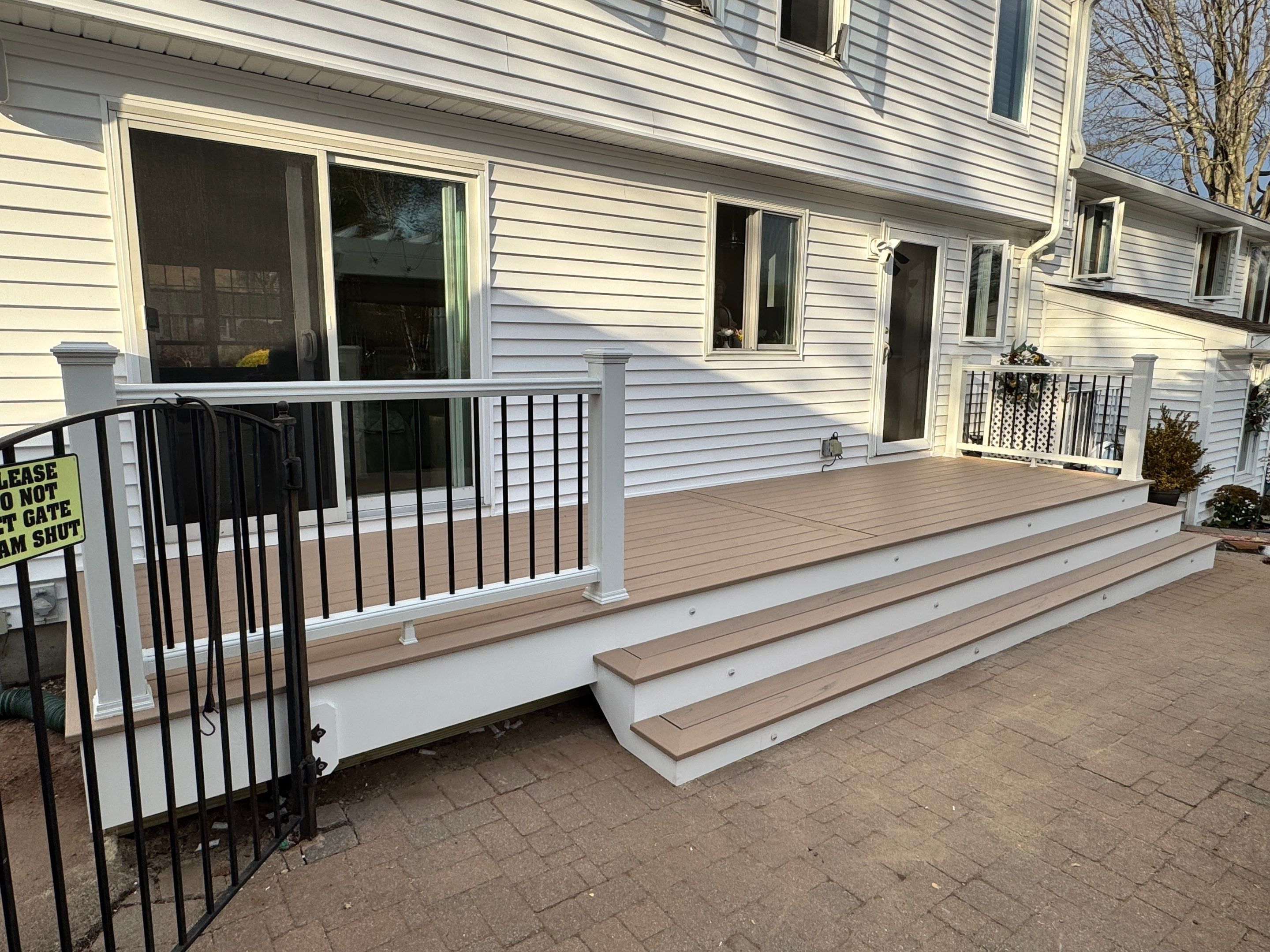 Replacement Deck using Tres Lineage Carmel boards and White Composite railing. by DiGiorgi Roofing and Siding Inc