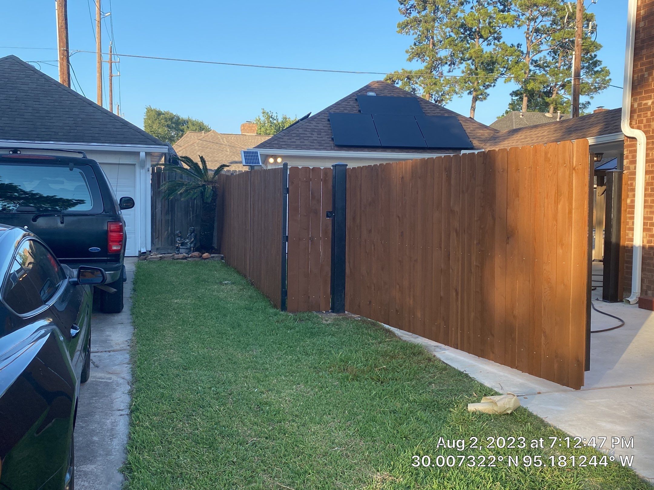 Complete metal driveway gate install with solar powered opener. Metal fence frame with Cedar Pickets by Astro Outdoor Designs 