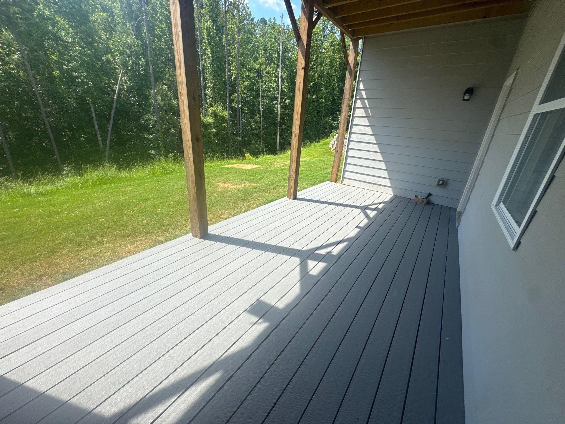 Ground-Level Gray Composite Deck and Privacy Fence Installation by Swift Home Renovations