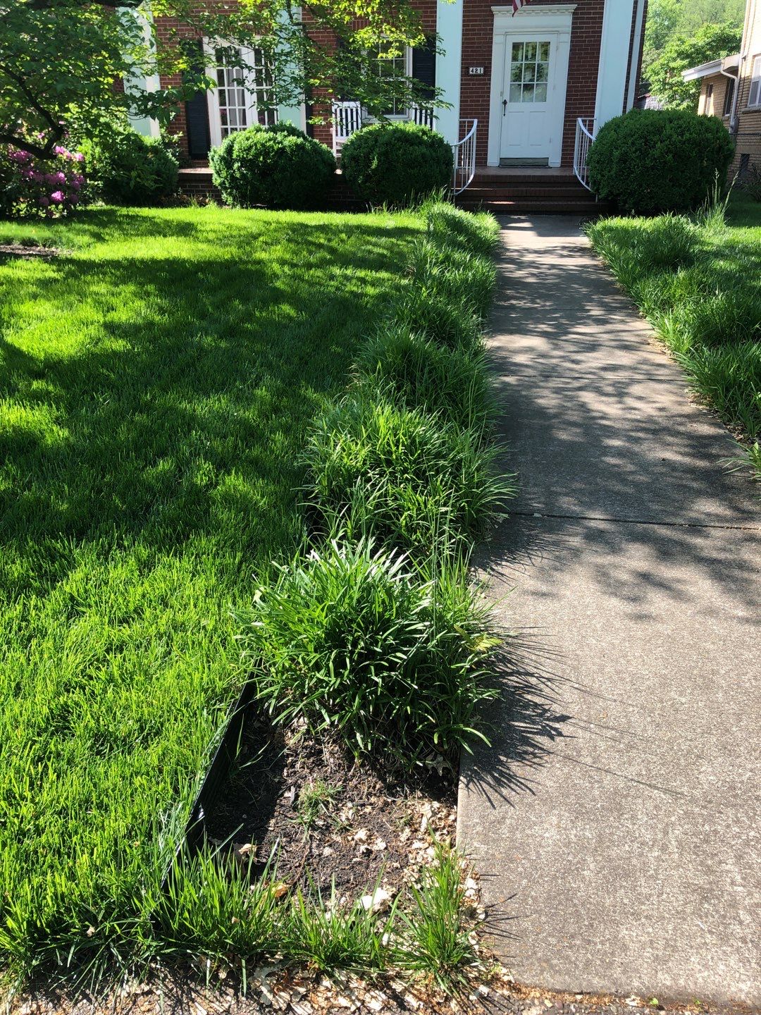 Liriope grasses, mulch and stone pavers by GrassBusters, Inc.