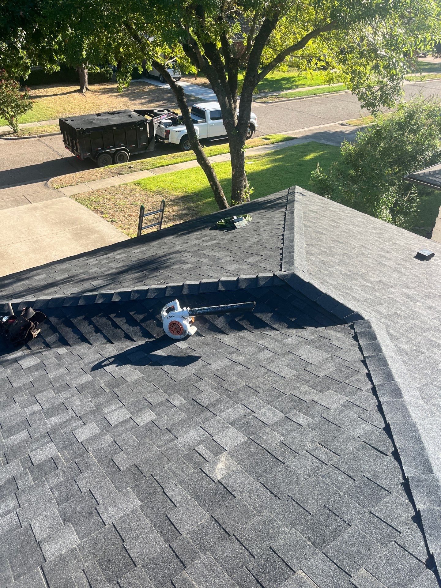 White brick/light gray shutters with IKO Granite Black  by Tejas Roofworks + Restoration