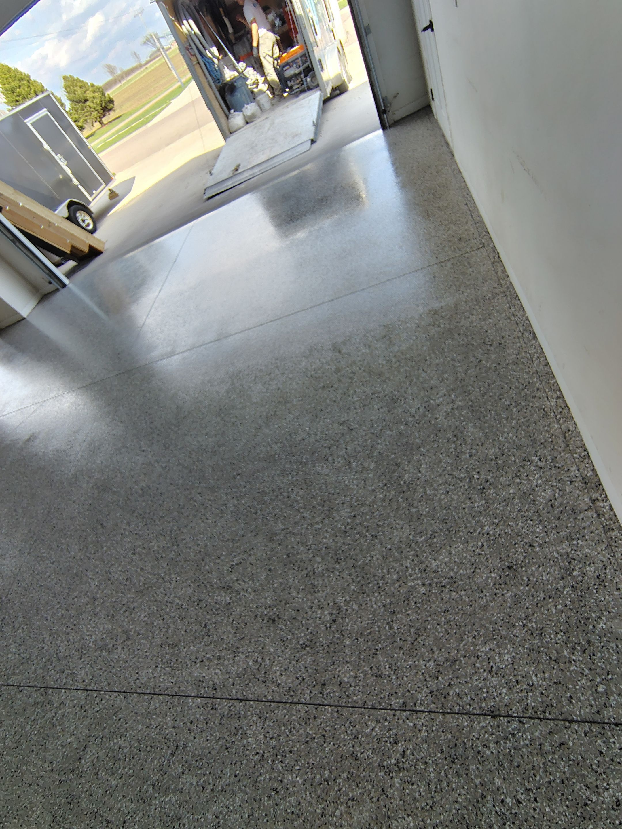 Speckled Polyaspartic Garage Floor Coating Installation in Dell Rapids by Select Painting, Coatings & Garage Cabinets