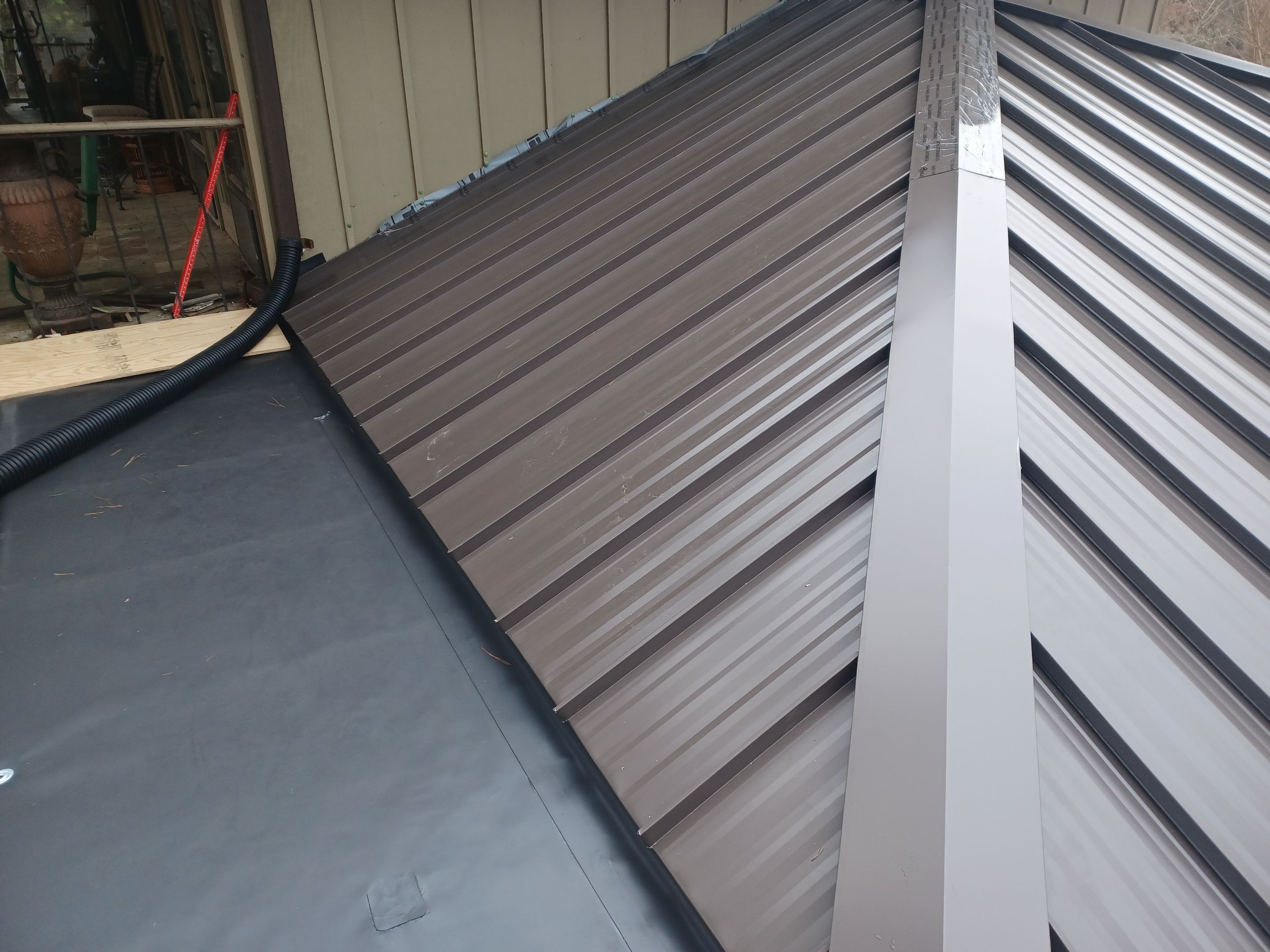 Residential Roofing Installation using PVC membrane and 24 gauge Standing Seam Metal by Hostetler Roofing