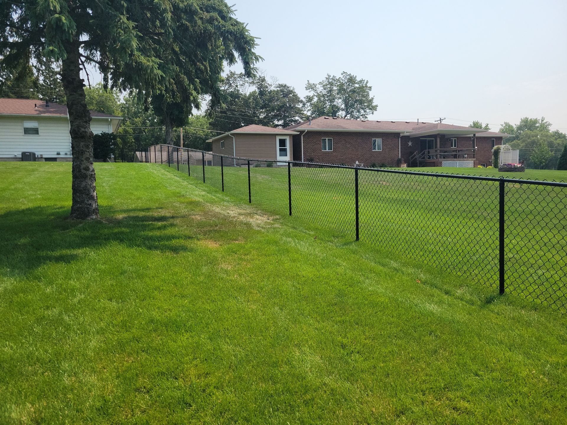 Black Vinyl-Coated Chain Link Fence Installation in New Hampton by Perfect Picket Fence and Stain