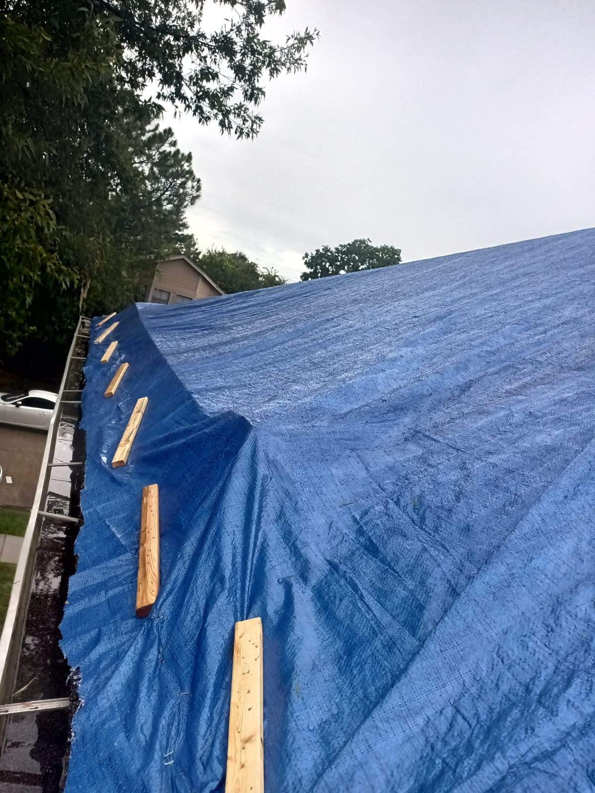 Placement of tarps on the roof. using TARP BLUE by V General Contractors 