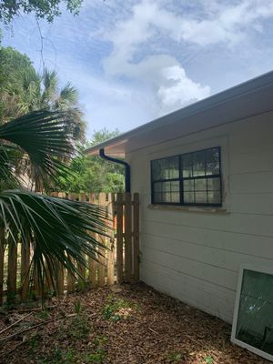 White Seamless Gutters and Black Downspouts