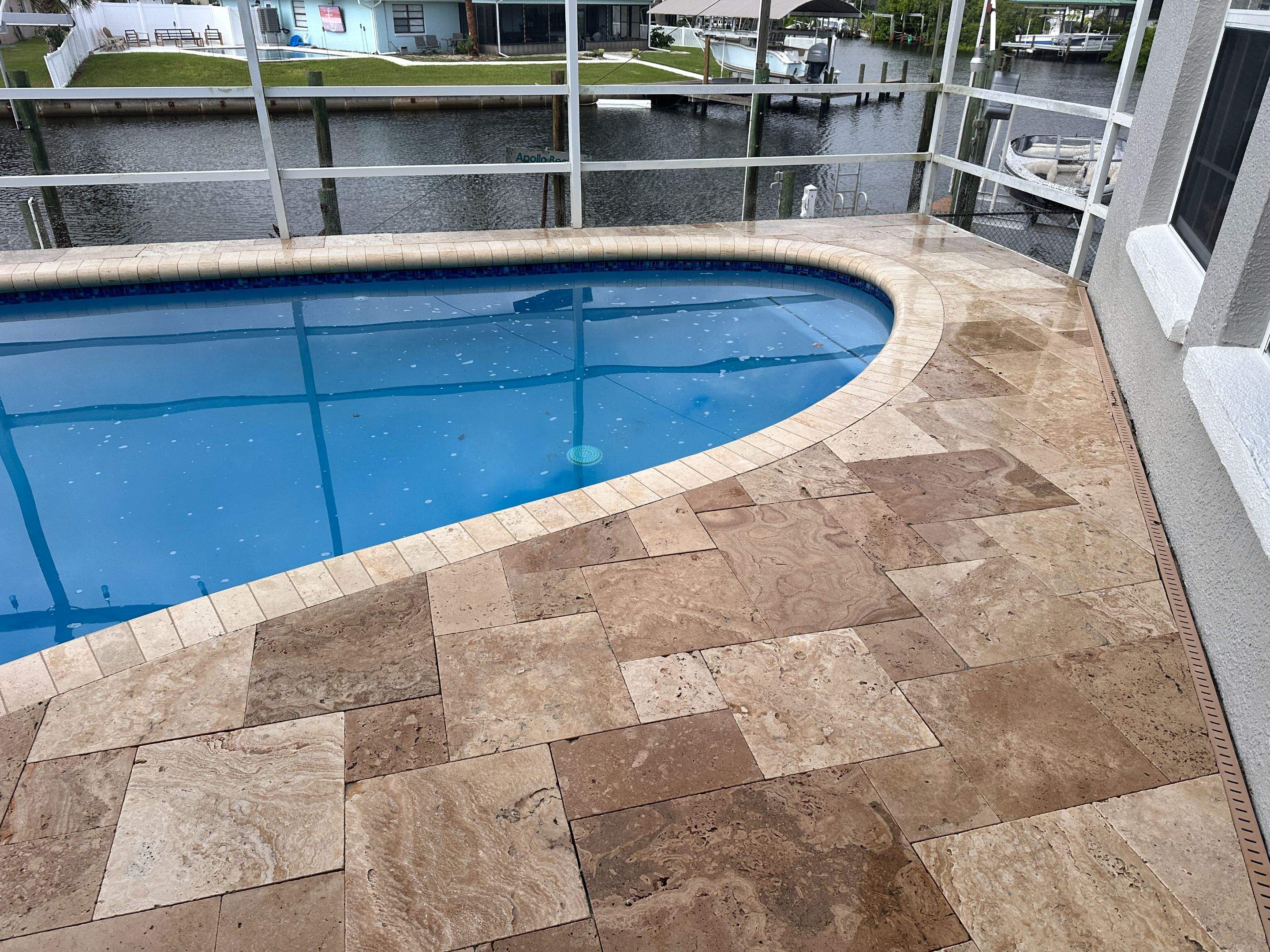 Travertine Sealing and Stripping for a Waterfront Pool Deck in Apollo Beach by Supreme Paver Experts