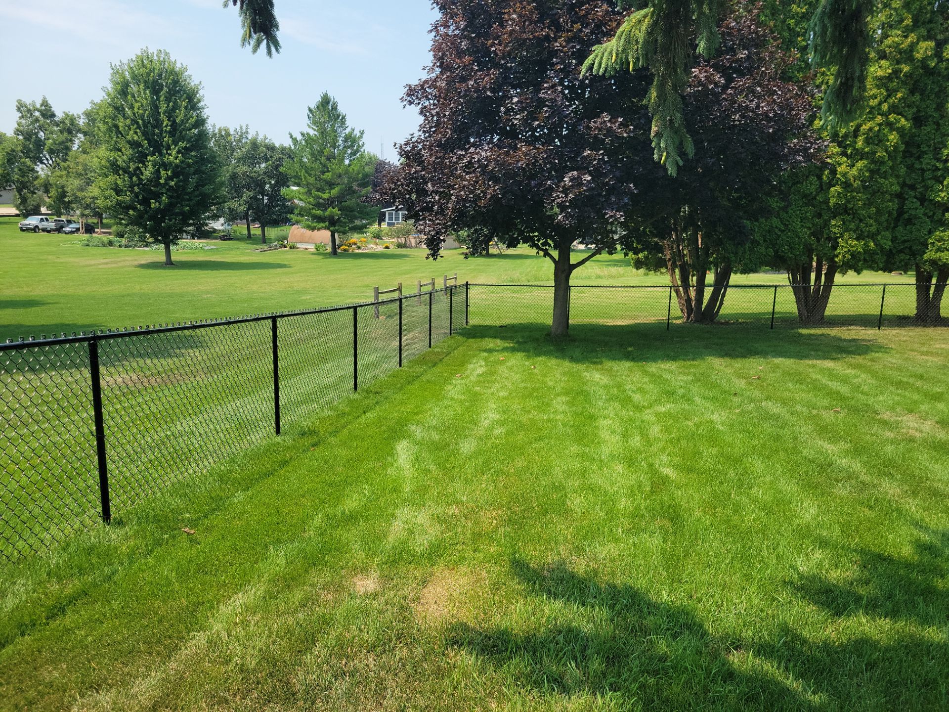 Black Vinyl-Coated Chain Link Fence Installation in New Hampton by Perfect Picket Fence and Stain