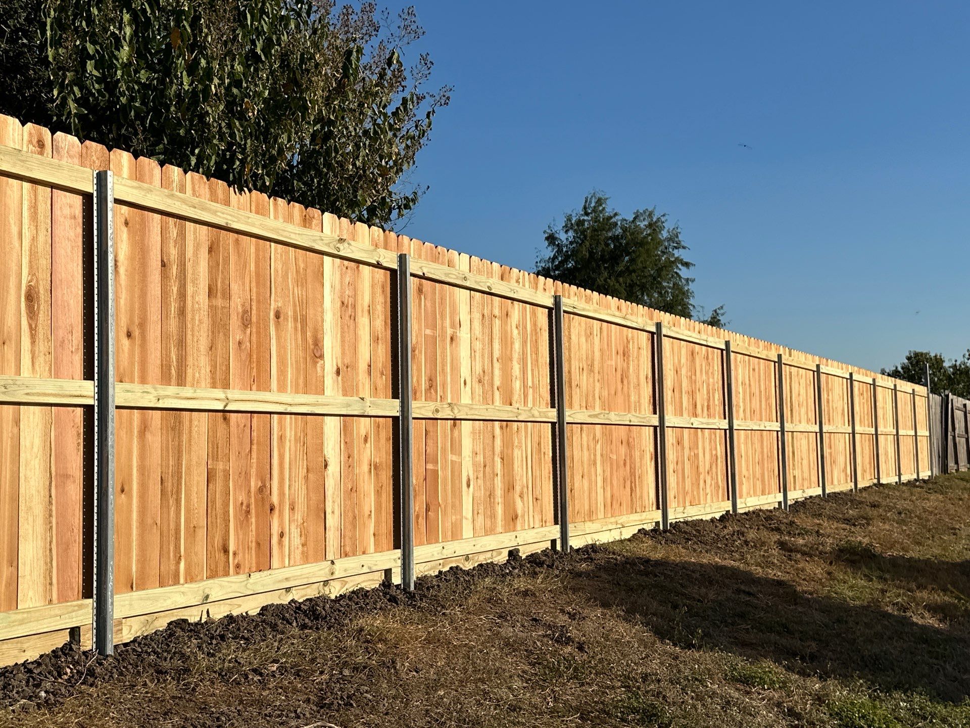 Beautiful Wood fence with metal posts by Tim's Fences