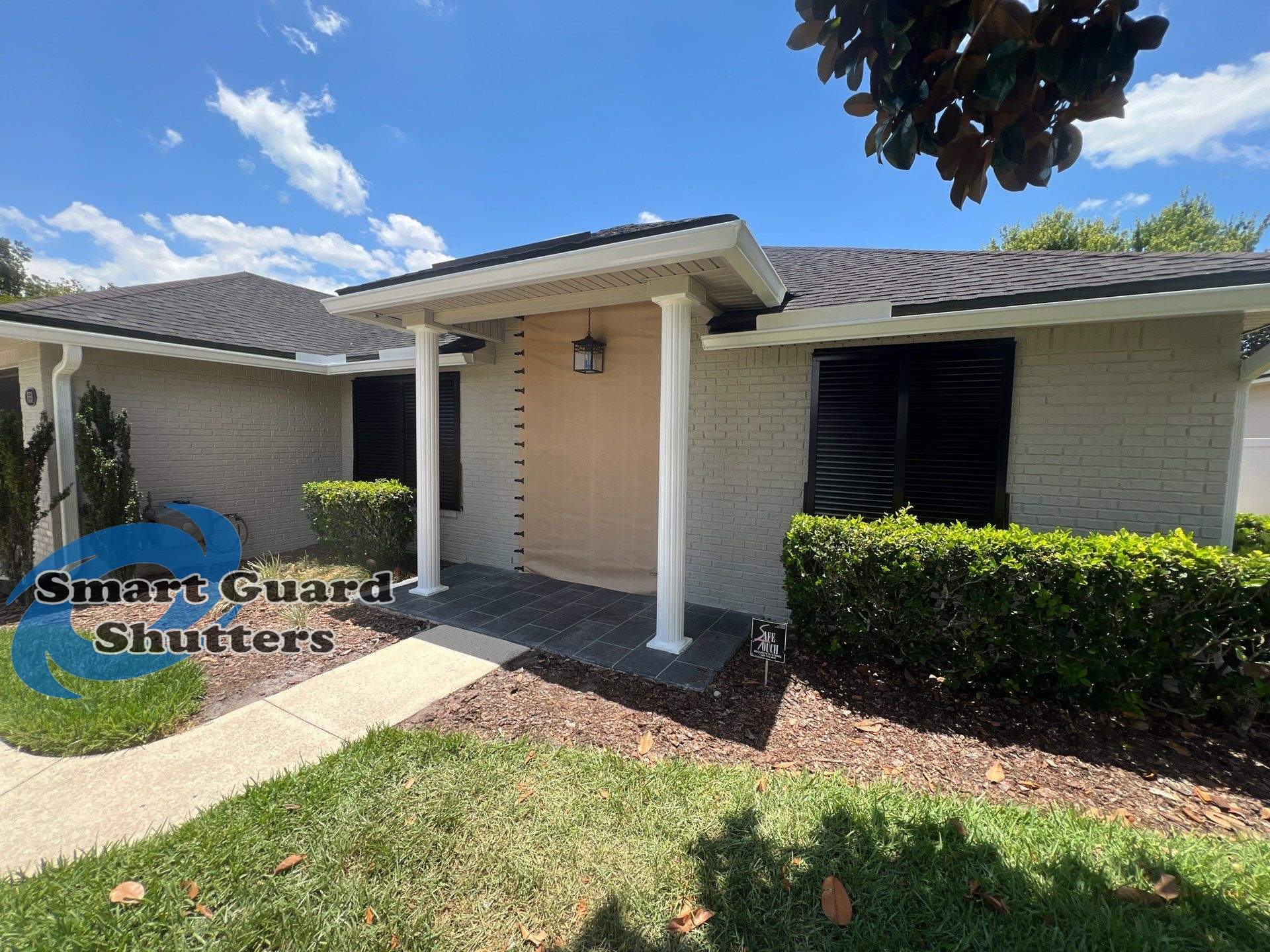 Hurricane Protection using Bahamas in Traffic Black and Fabric in Tan by Smart Guard Shutters