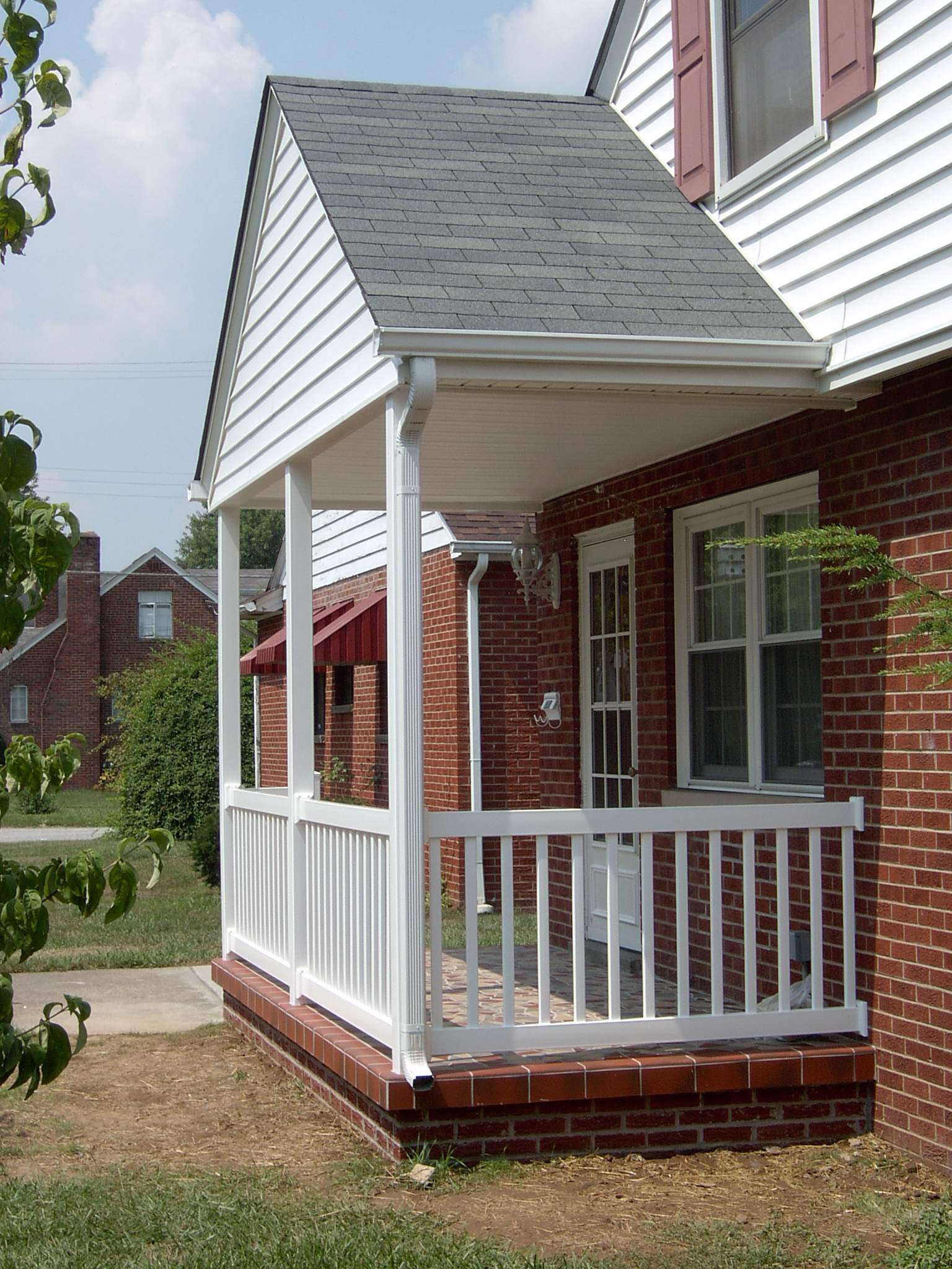 New front porch build, with tile floor and vinyl railing. by Secure Construction Company Inc