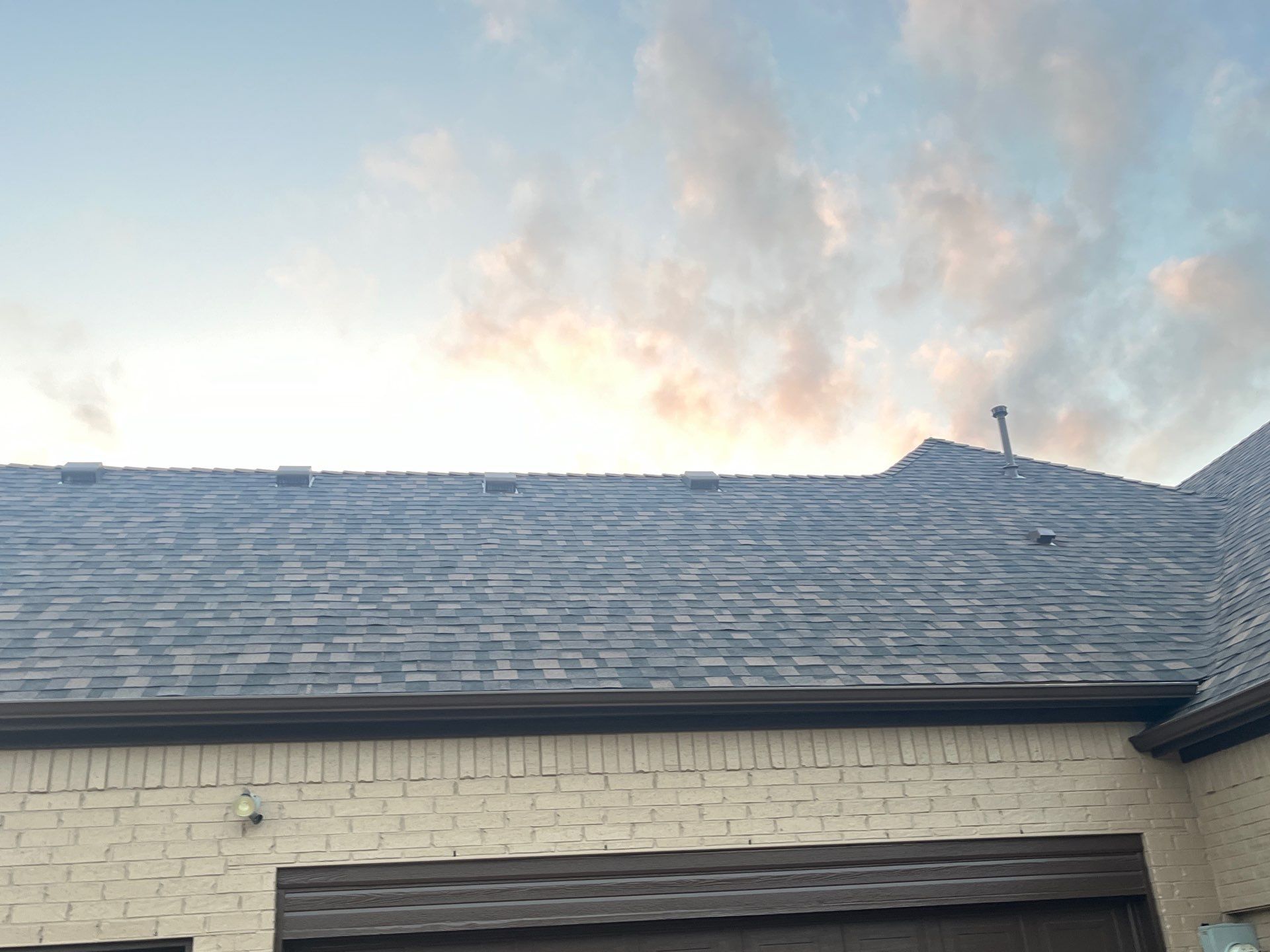 Cream brick/mixed stone with IKO Shadow Brown by Tejas Roofworks + Restoration