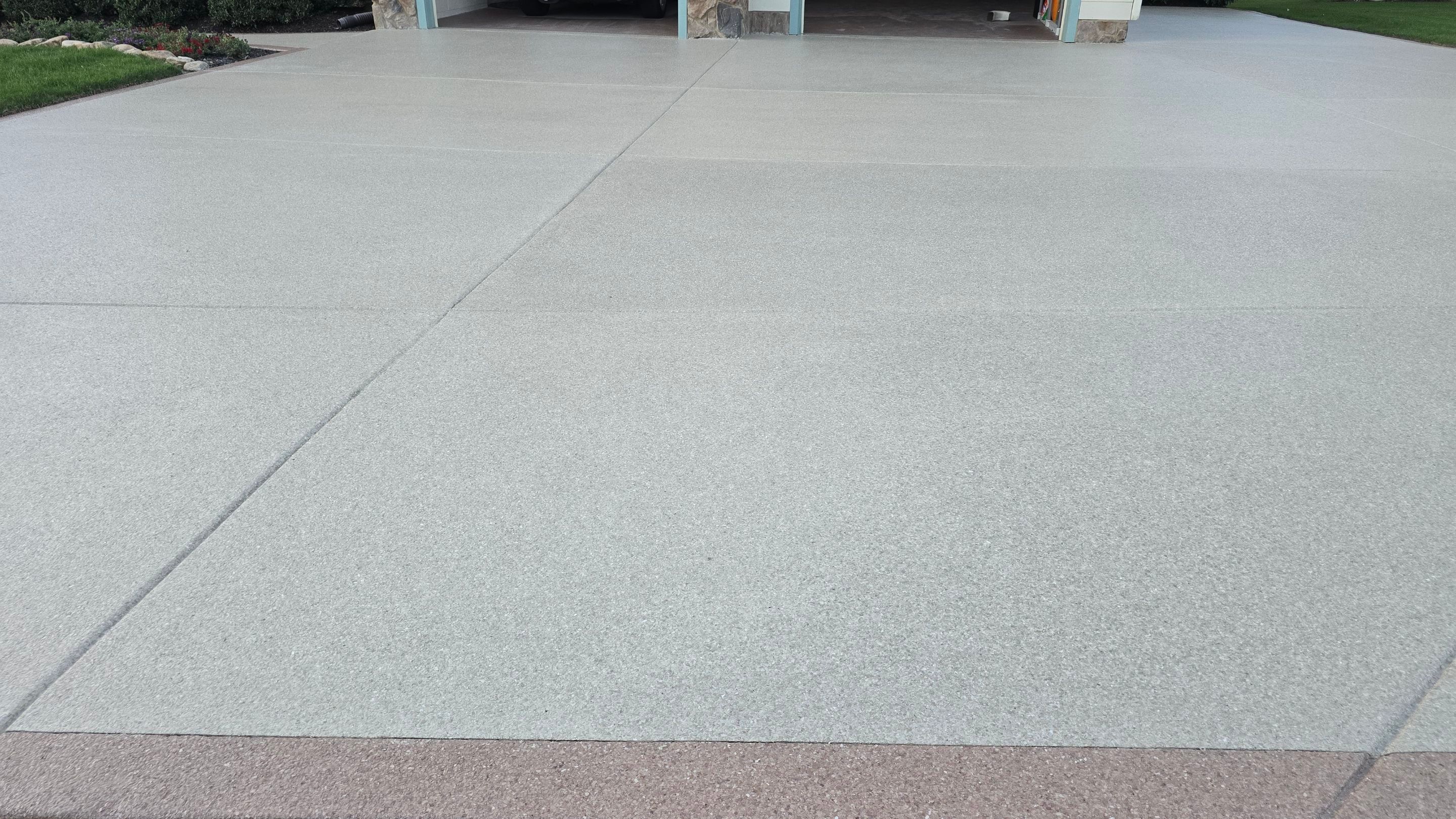 Driveway and sidewalk using Feldspar with the border done in Spilite by Elite Floor Solutions