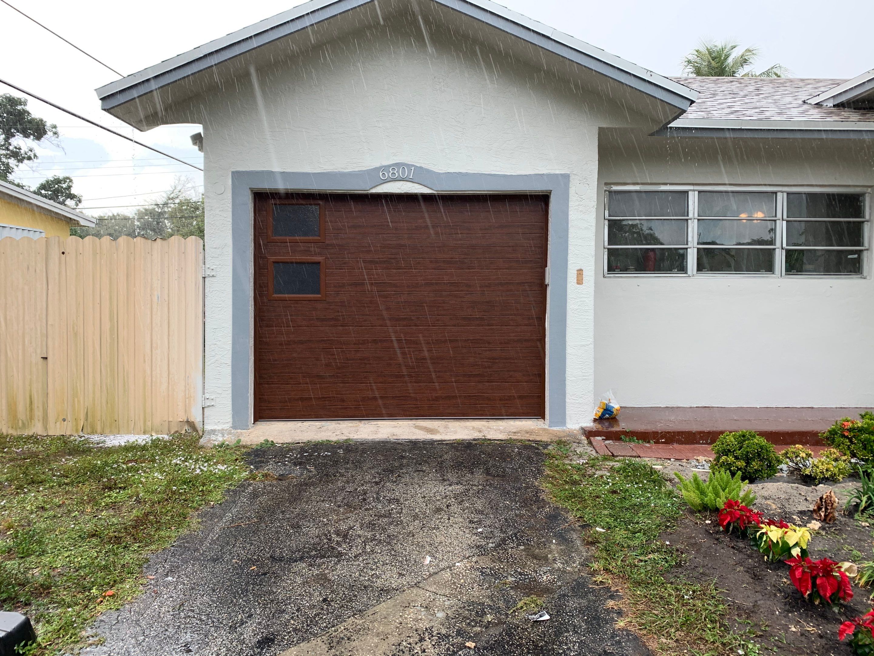 Sectional Garage Door Installation with Wood-Grain Finish in Sunrise - Clopay Modern Steel by The Door Doctor of South Florida, Inc.
