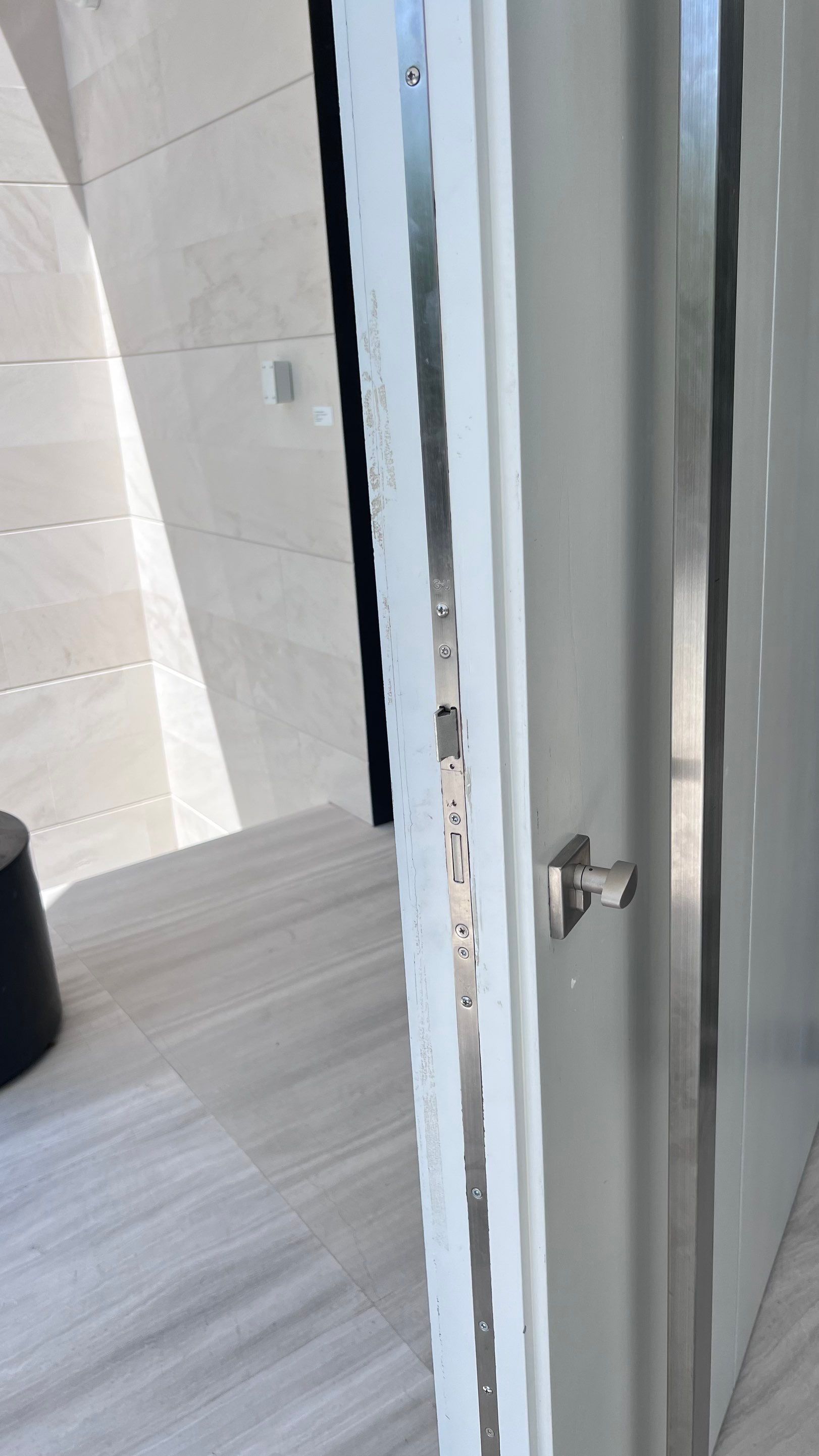 Custom Material Pivot Door installation by Impact Precious Wood Inc.