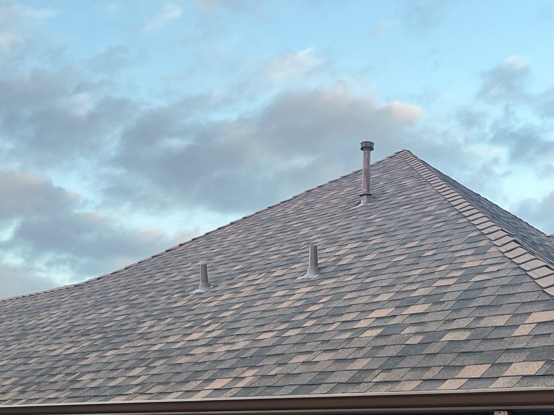 Cream brick/mixed stone with IKO Shadow Brown by Tejas Roofworks + Restoration