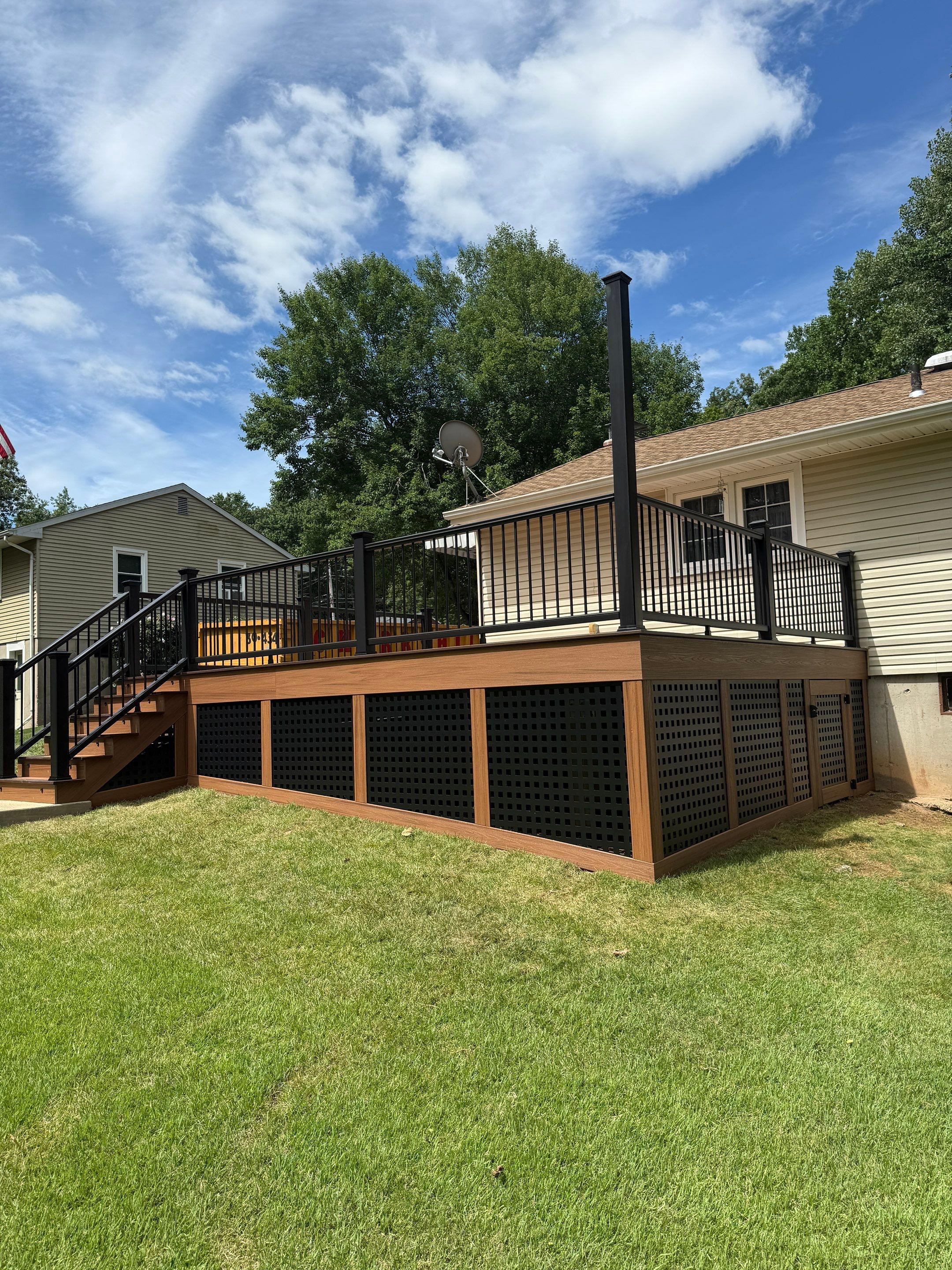 Replacement Deck, Trex Tropical Tiki torch , Matching Fascia. Black Transcend railing and Lattice. by DiGiorgi Roofing and Siding Inc