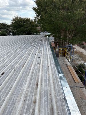Metal roof panels with scaffolding and edge flashing