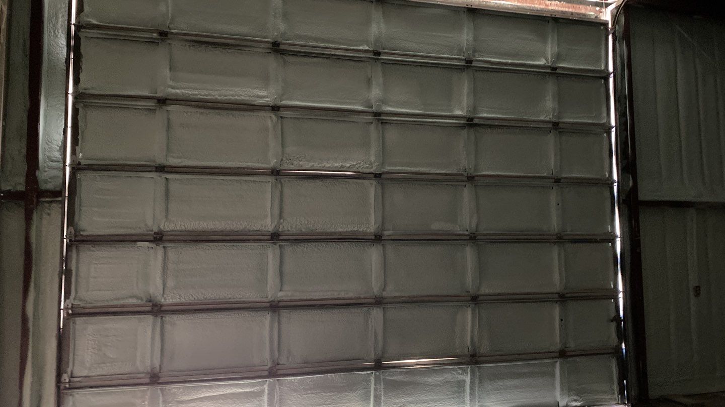 Spray foam insulation on inside of metal industrial building by Straight Edge Roofing Inc