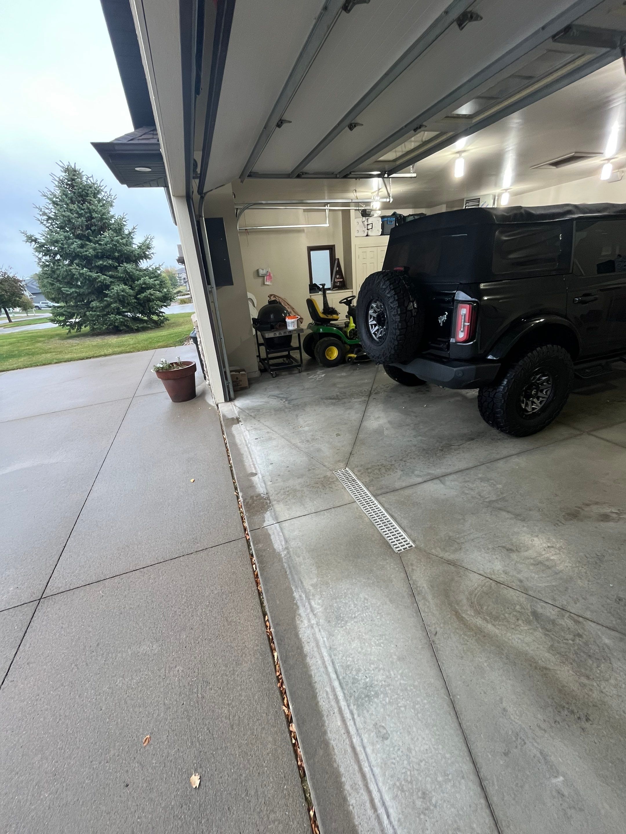 Coyote Flake Garage Floor Coating in Sioux Falls with Trench Drain by Select Painting, Coatings & Garage Cabinets