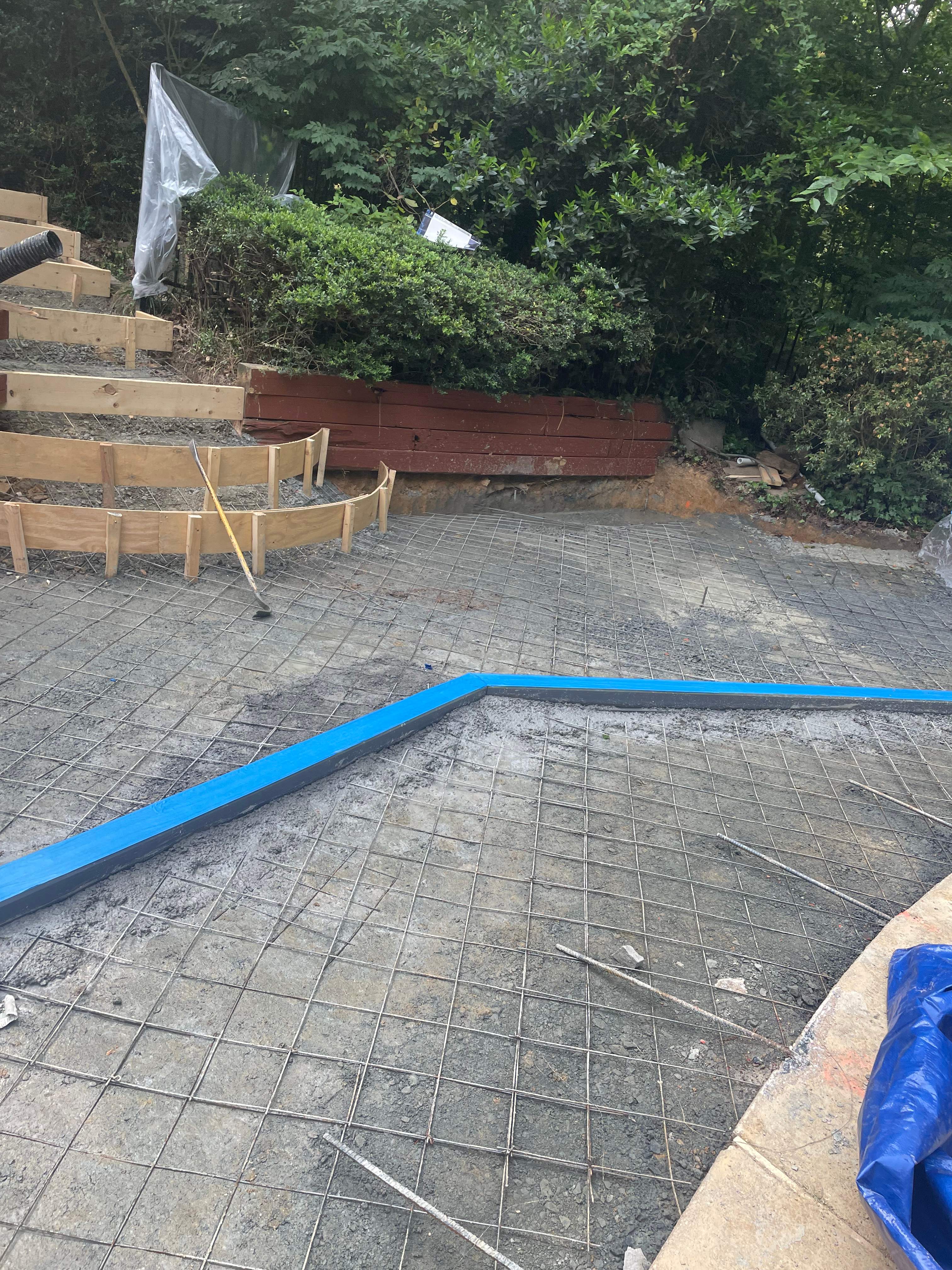 Pool Surround remodel with retaining walls, new waterfall and water slide by Fairfax Contractors, LLC