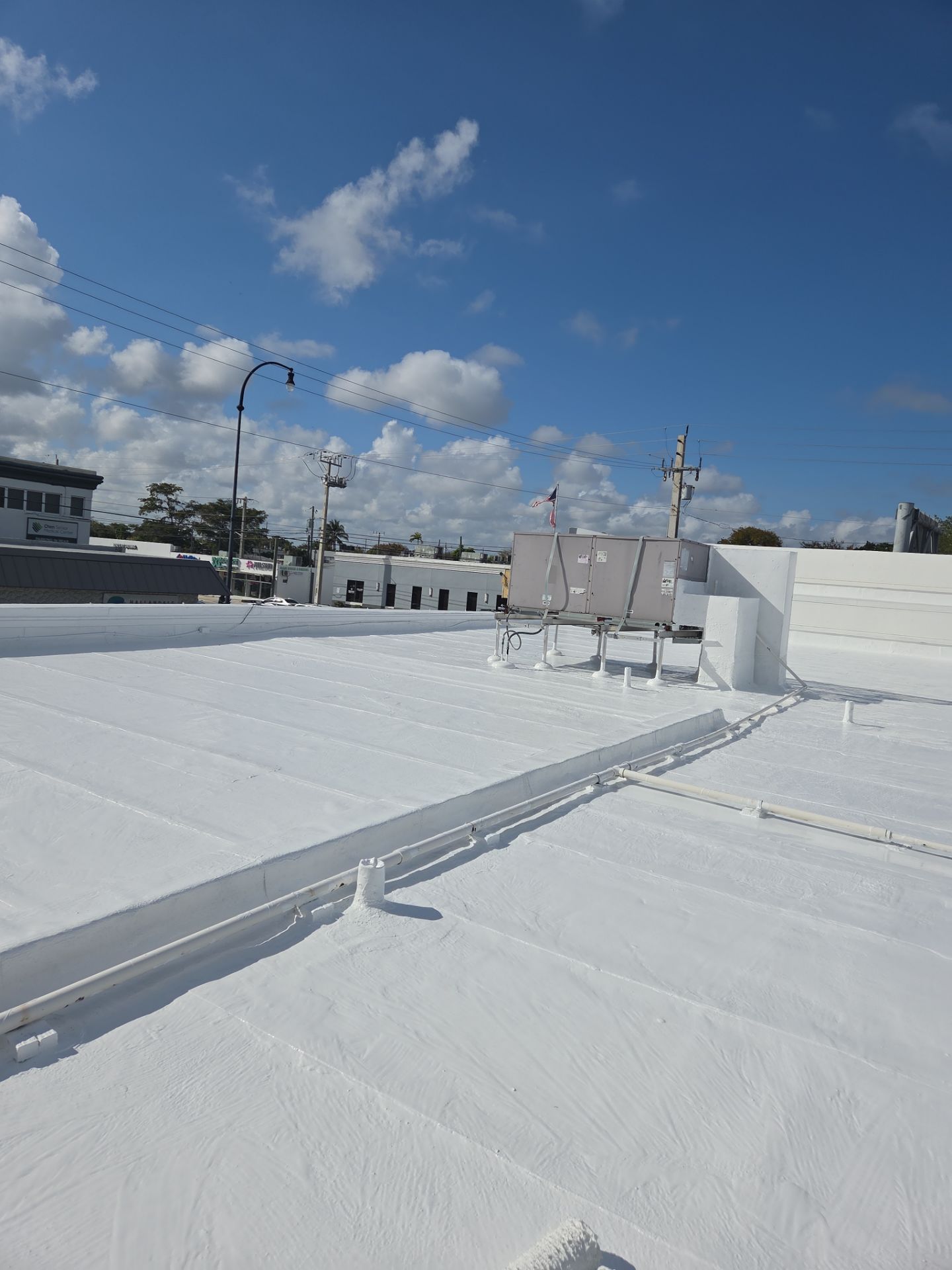 Commercial Flat Roof Restoration Using Silicone Coating in Hallandale Beach by Aastro Roofing
