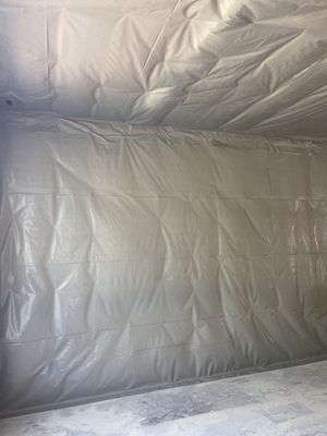 Plastic sheeting covering walls and ceiling in an interior containment area.