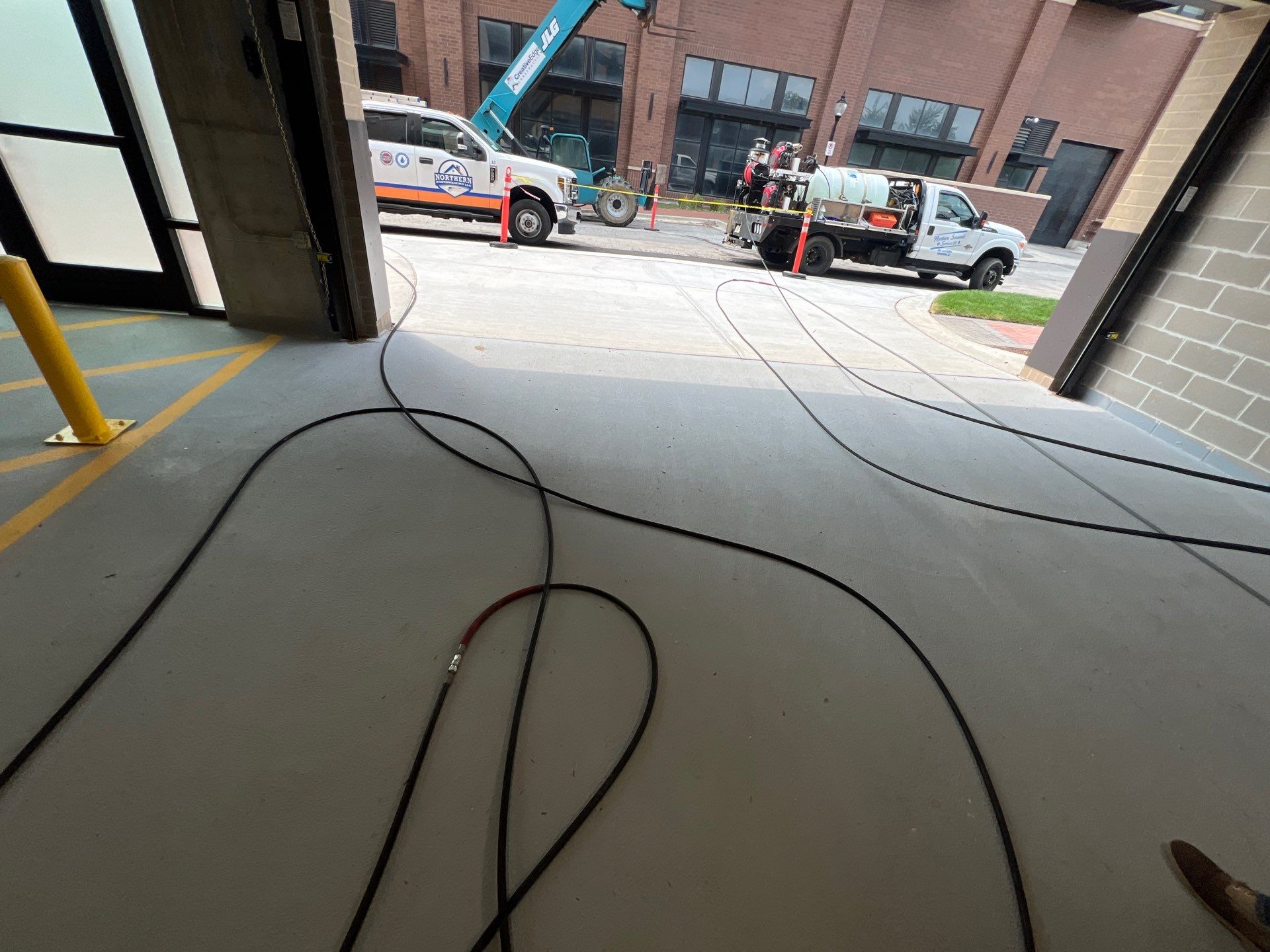 Parking garage using Hot water by Northern Power Washing LLC.