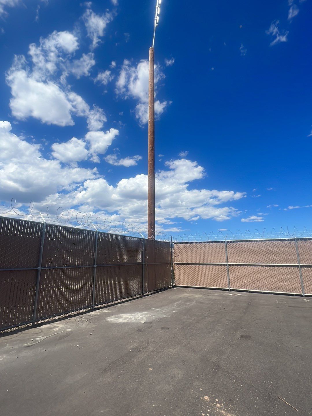 Commercial       using 8'+1' 9ga chain link with slats and razor wire by Valley Fence Company