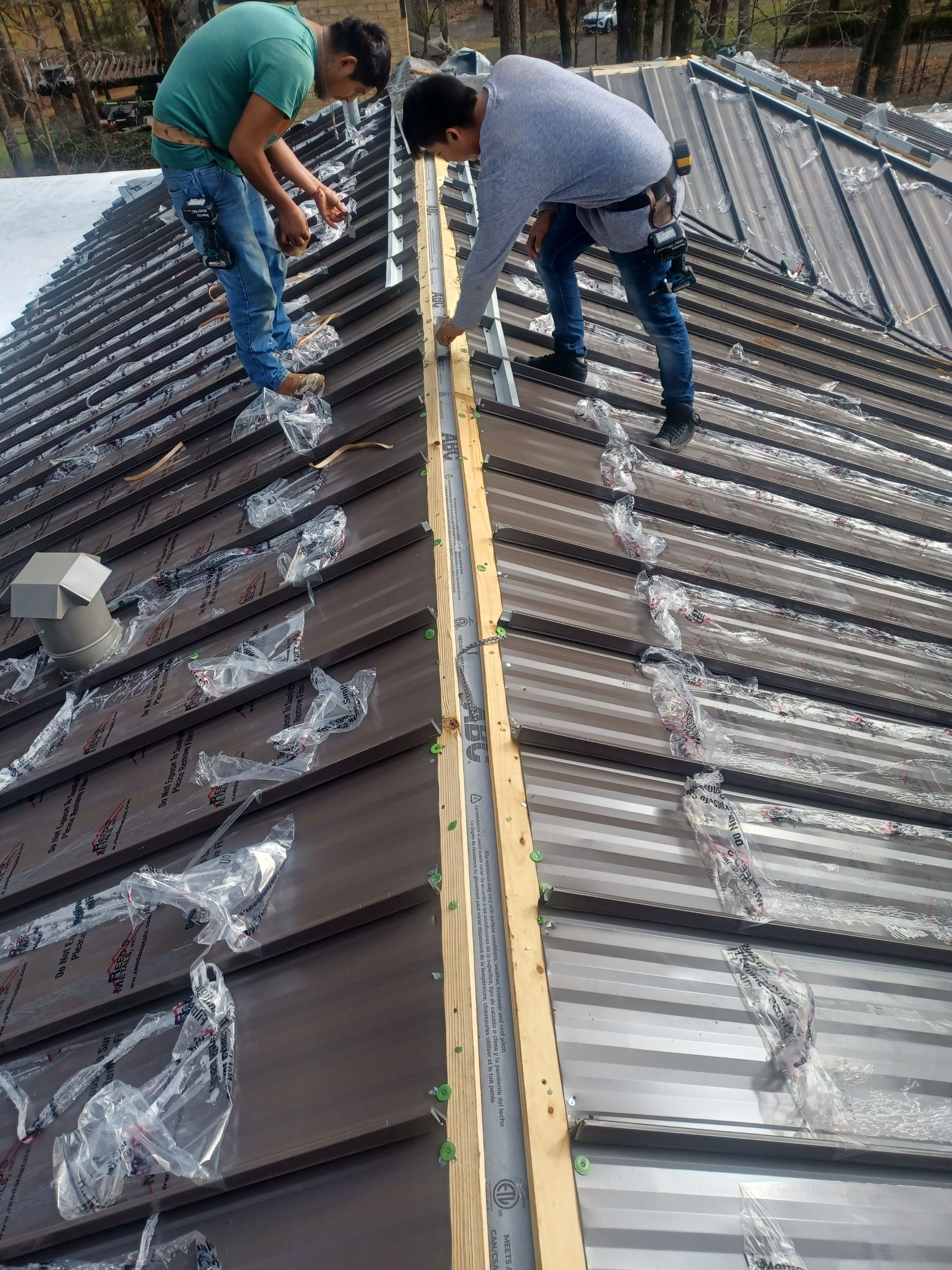 Residential Roofing Installation using PVC membrane and 24 gauge Standing Seam Metal by Hostetler Roofing