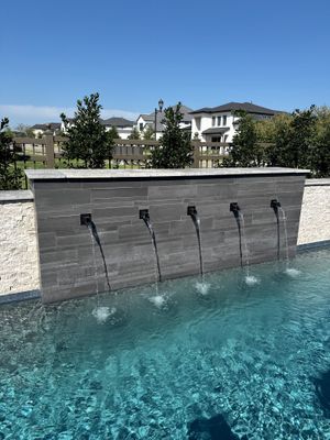 Geometric Pool with Raised Stone Scupper Wall and Outdoor Kitchen