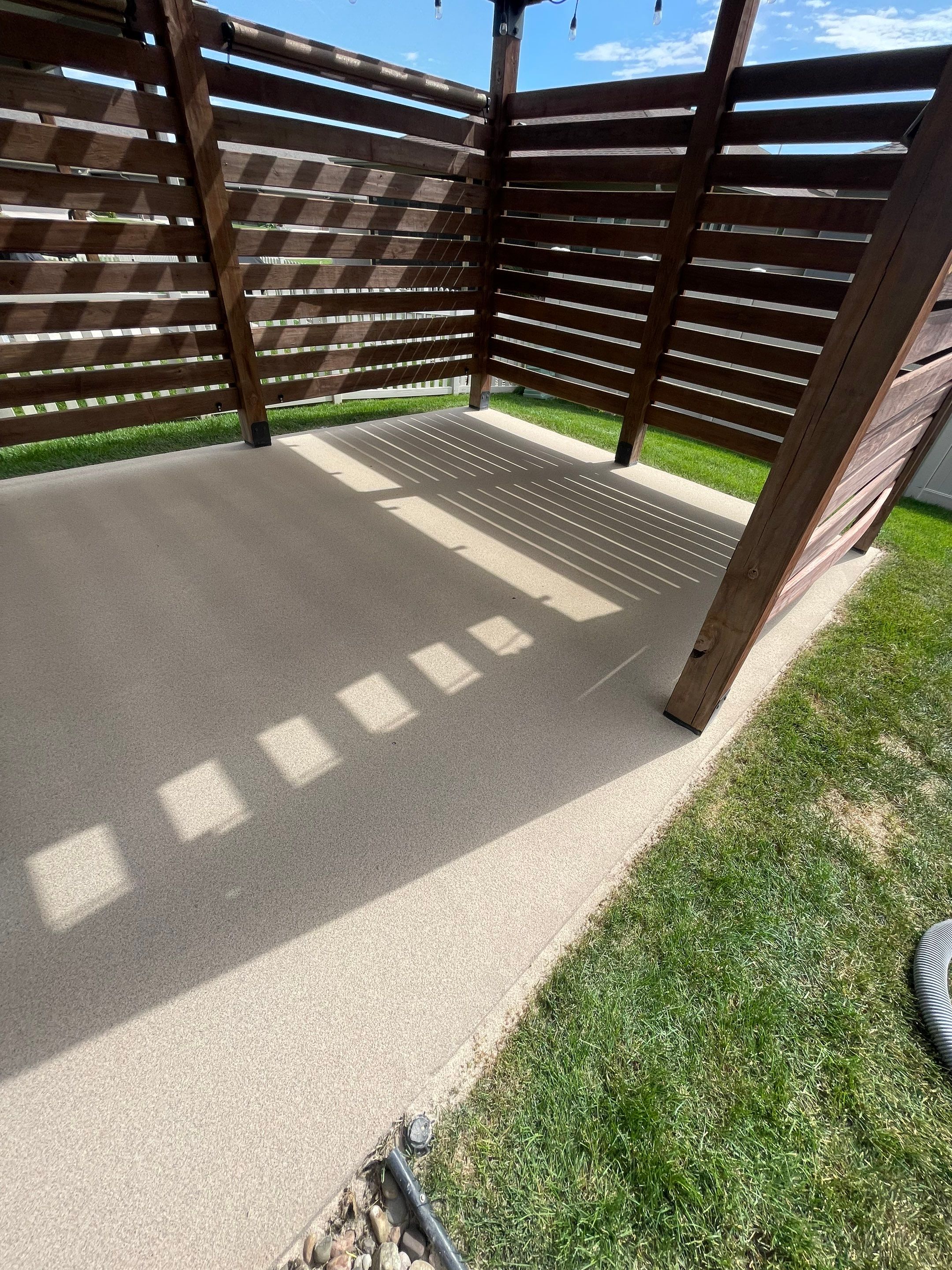 Textured Concrete Patio Coating and Custom Privacy Pergola in Sioux Falls by Select Painting, Coatings & Garage Cabinets