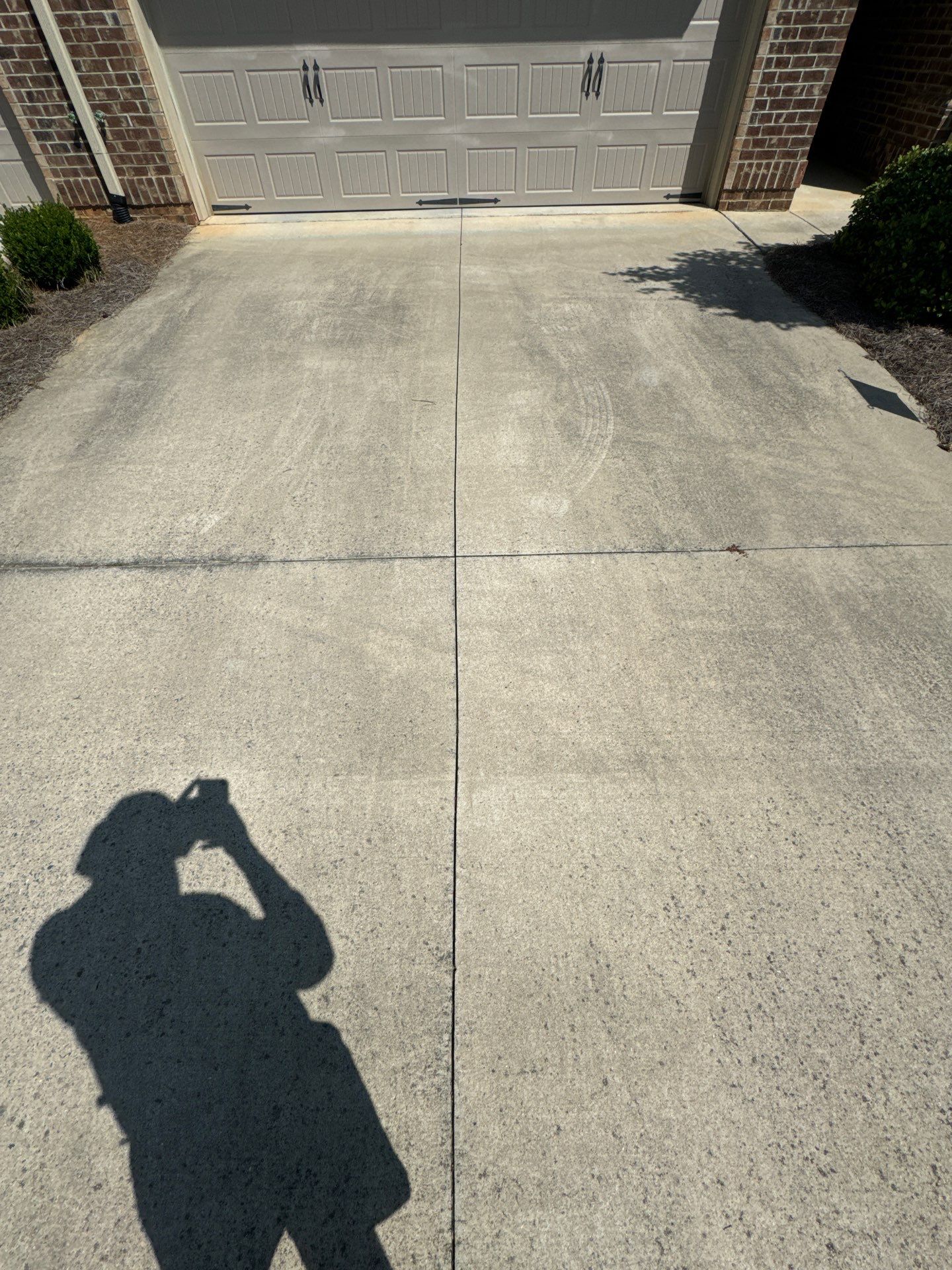 the service being done is driveway cleaning removing dirt and stains from the concrete surface for enhanced curb appeal