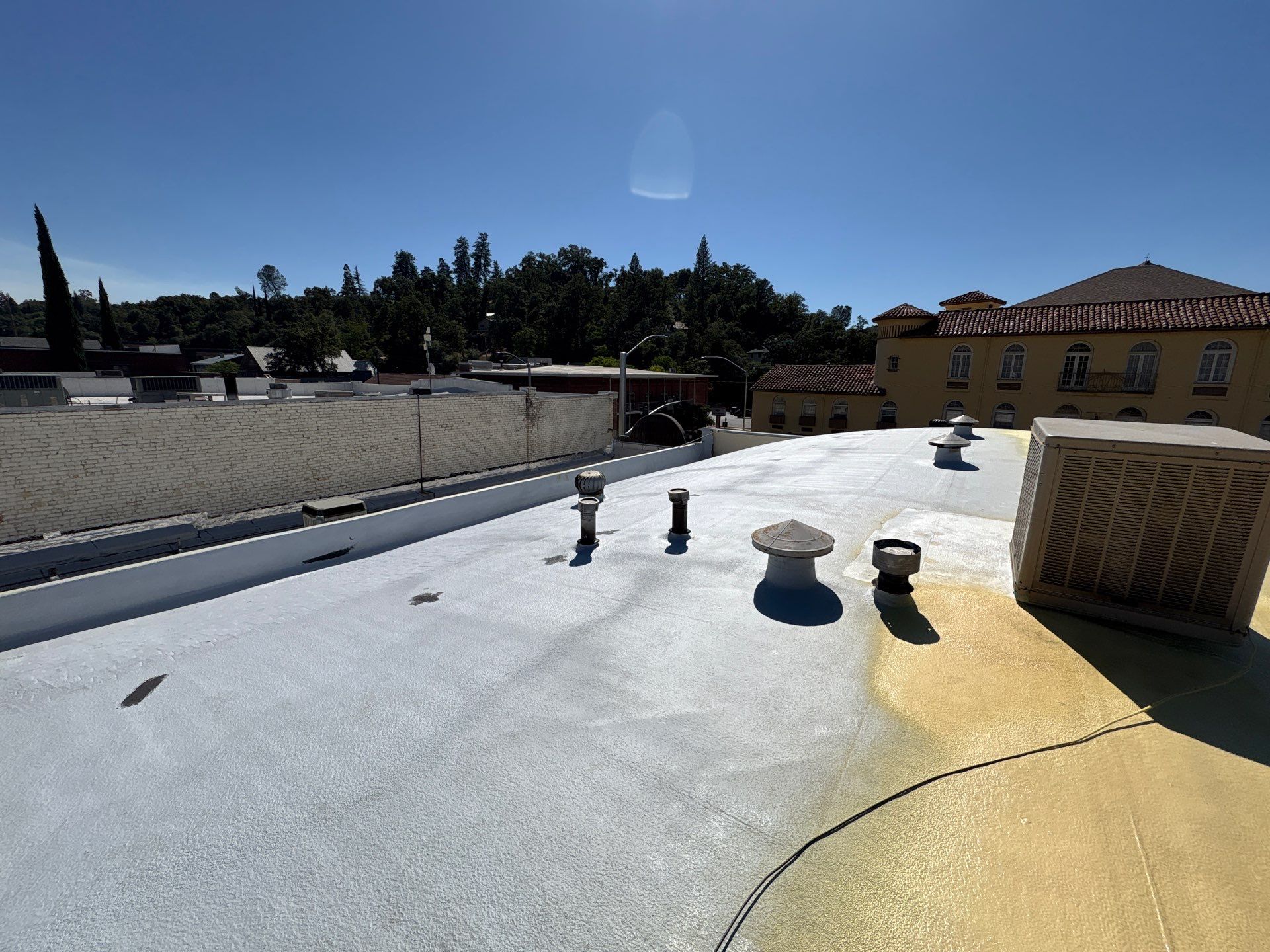 Foam and coatings on commercial roof by Straight Edge Roofing Inc