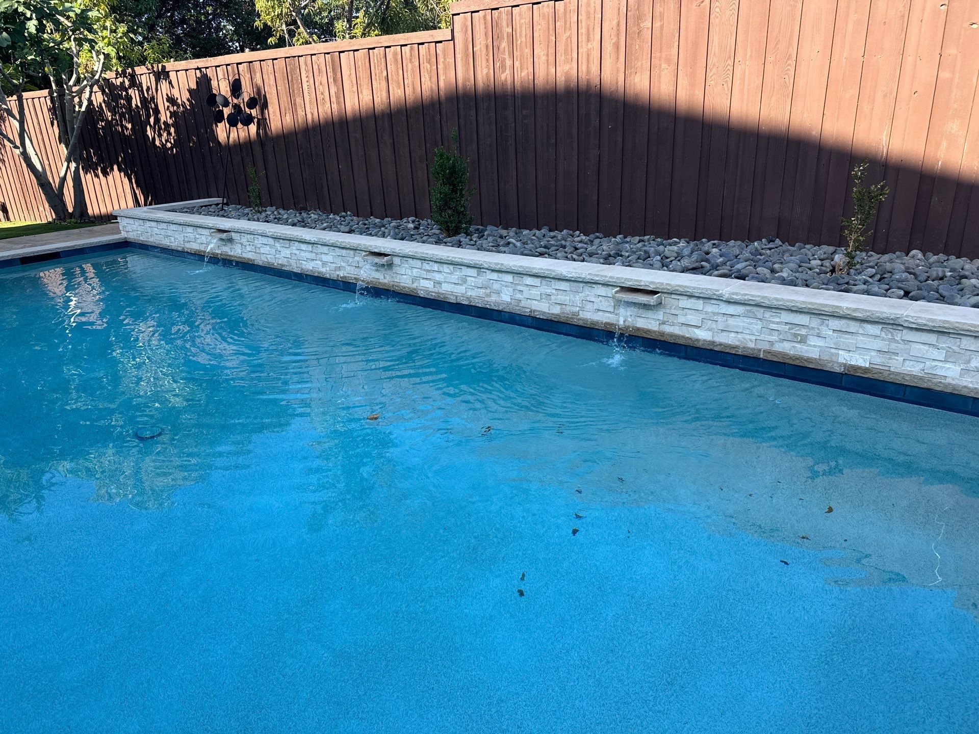 Geometric Pool with Raised Stone Waterfall Wall by Pinnacle Pools and Spas - DFW