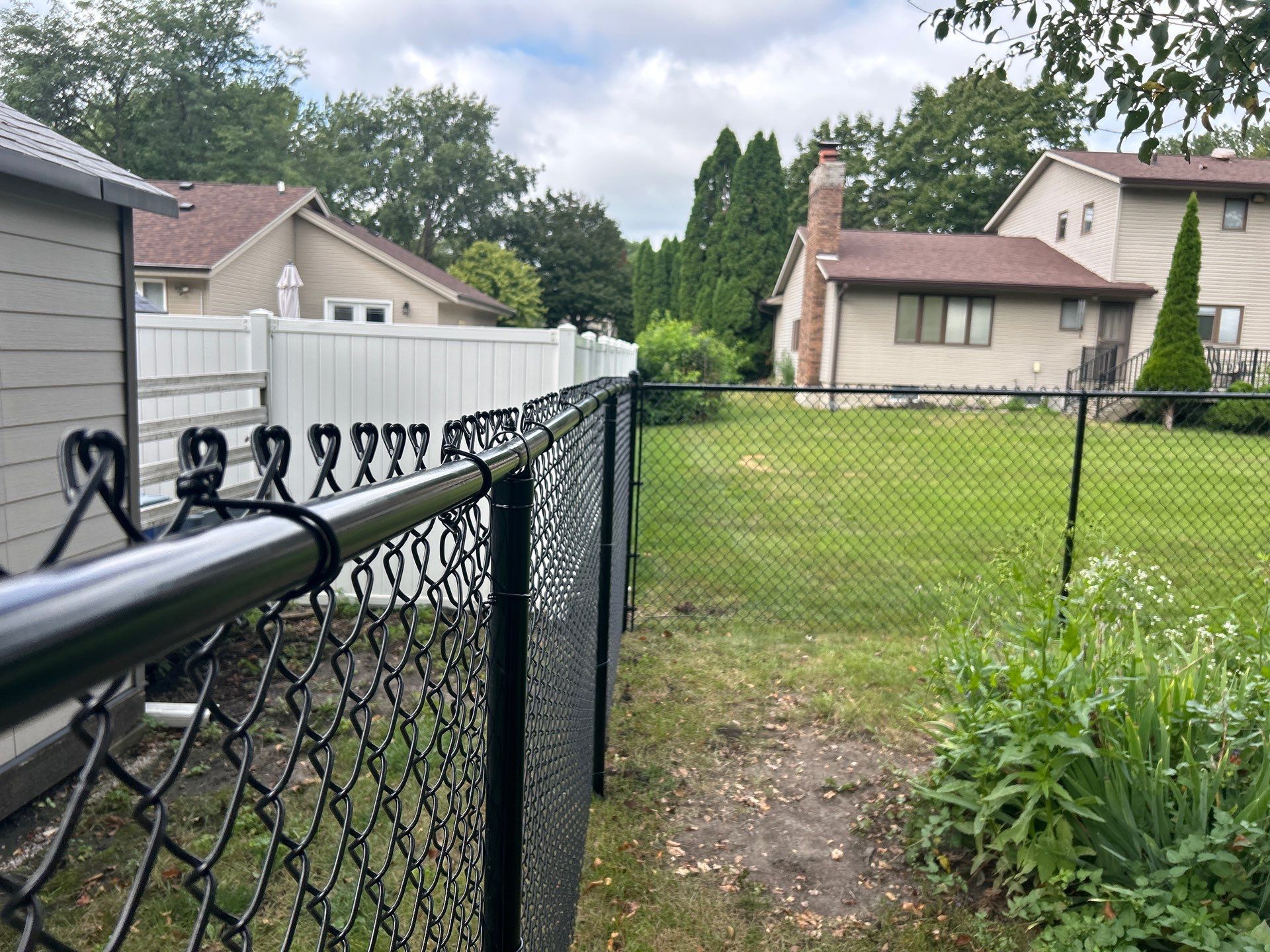 Black Vinyl Coated Chain Link Fence Installation in Waterloo by Perfect Picket Fence and Stain