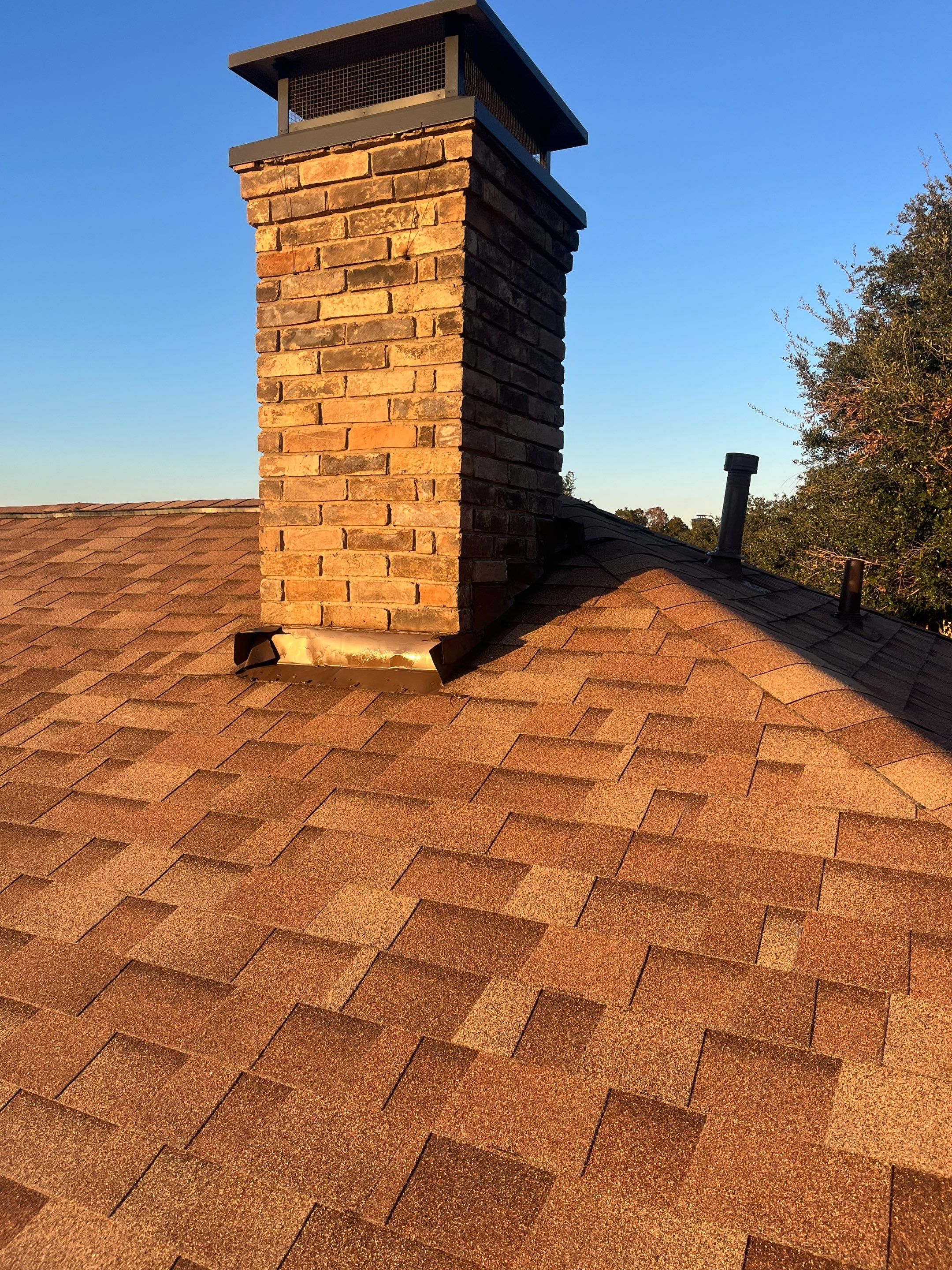 Brick with white area around windows with Malarkey Sienna Blend by Tejas Roofworks + Restoration