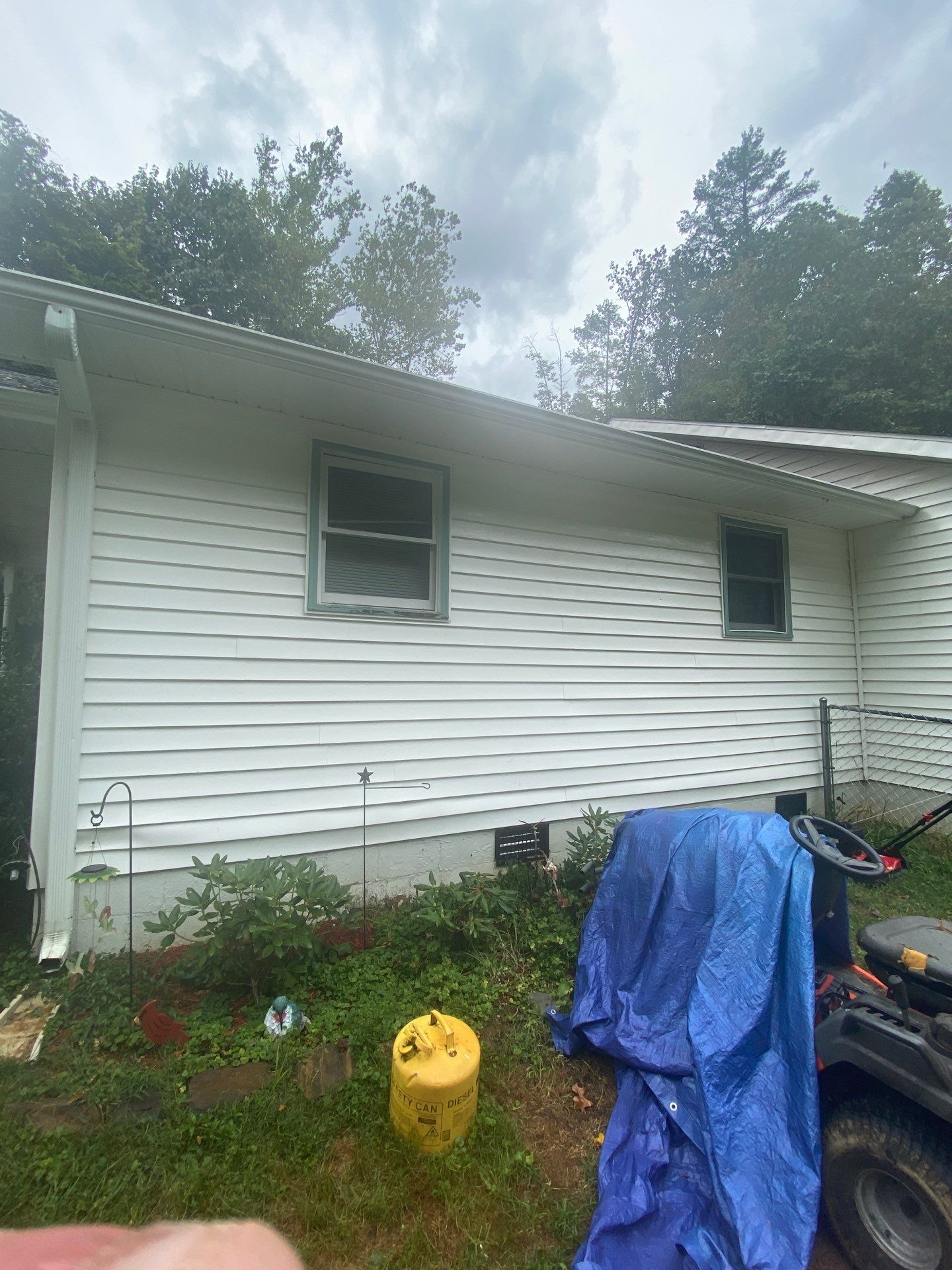 the service is pressure washing the exterior siding of the house to remove dirt and grime build up