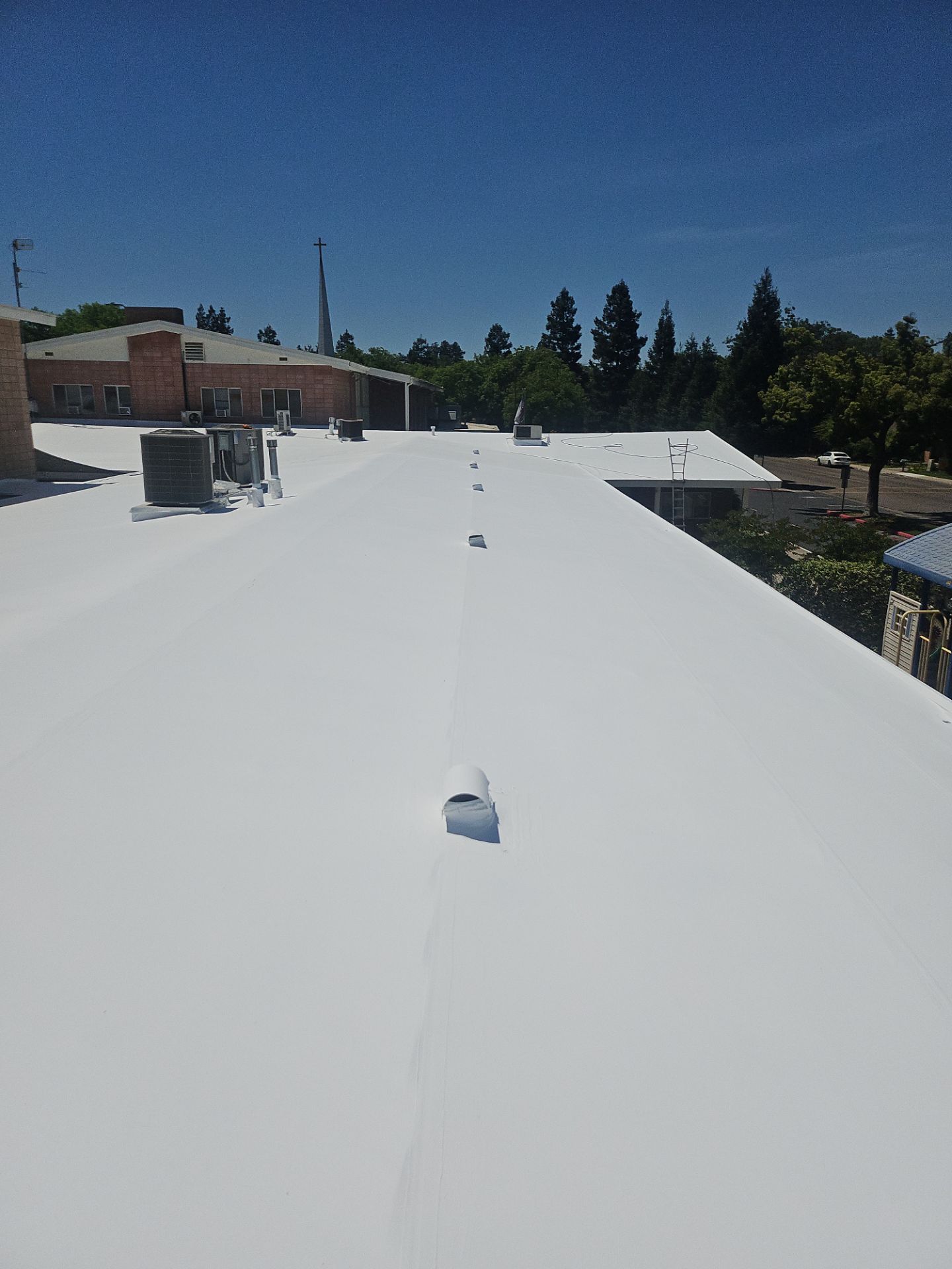 Single-ply restoration system using Benchmark/PUMA XL coatings over TPO single-ply roofing by Straight Edge Roofing Inc