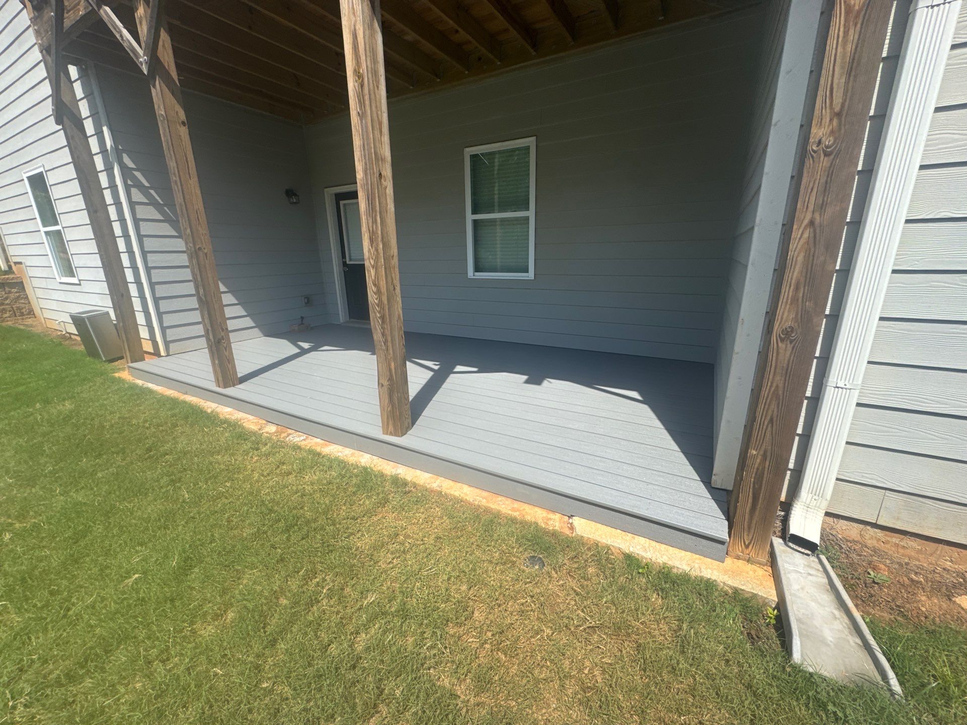 Ground-Level Gray Composite Deck and Privacy Fence Installation by Swift Home Renovations