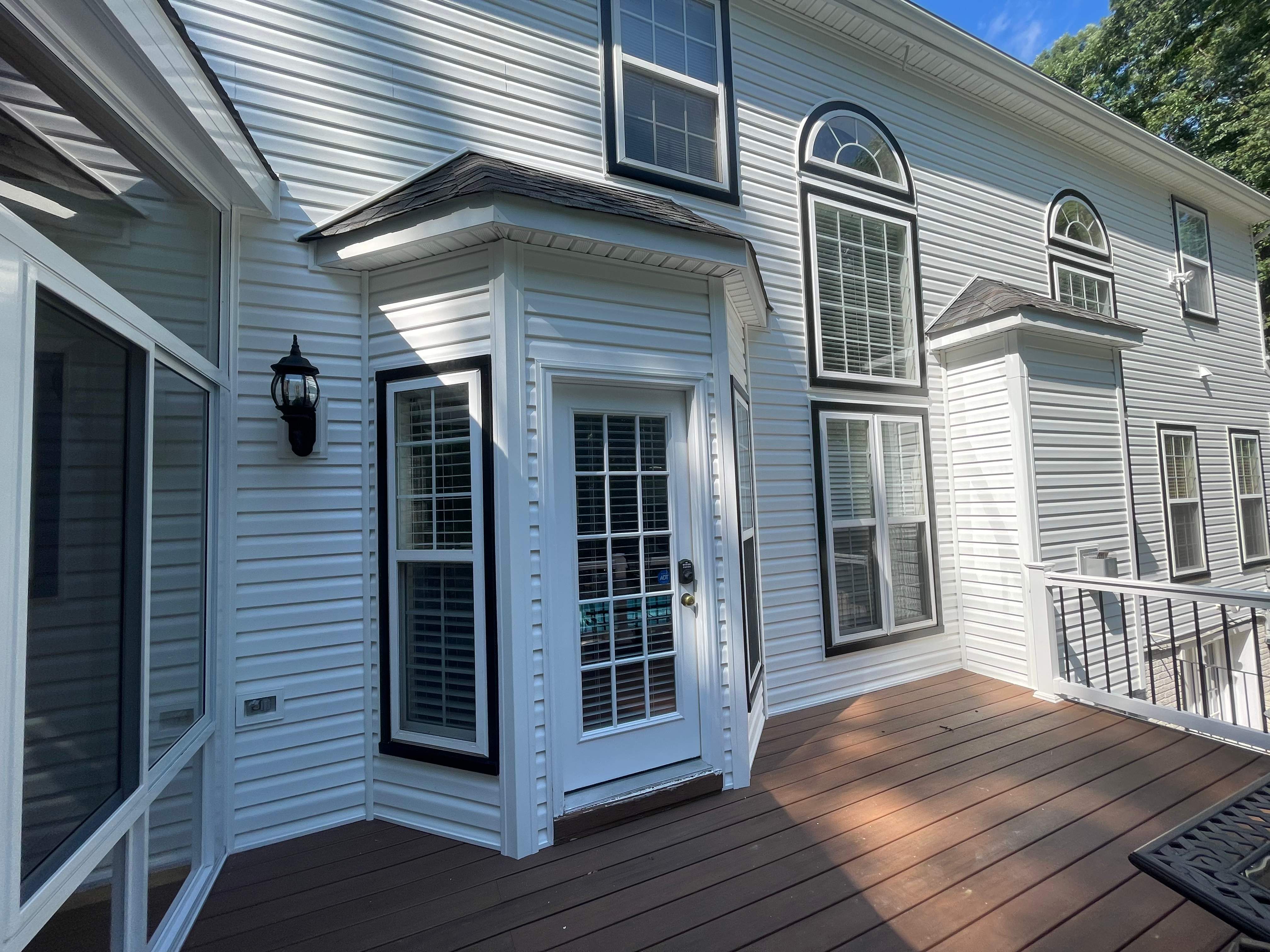 Vinyl Siding Replacement + Black Trim by American Home Contractors