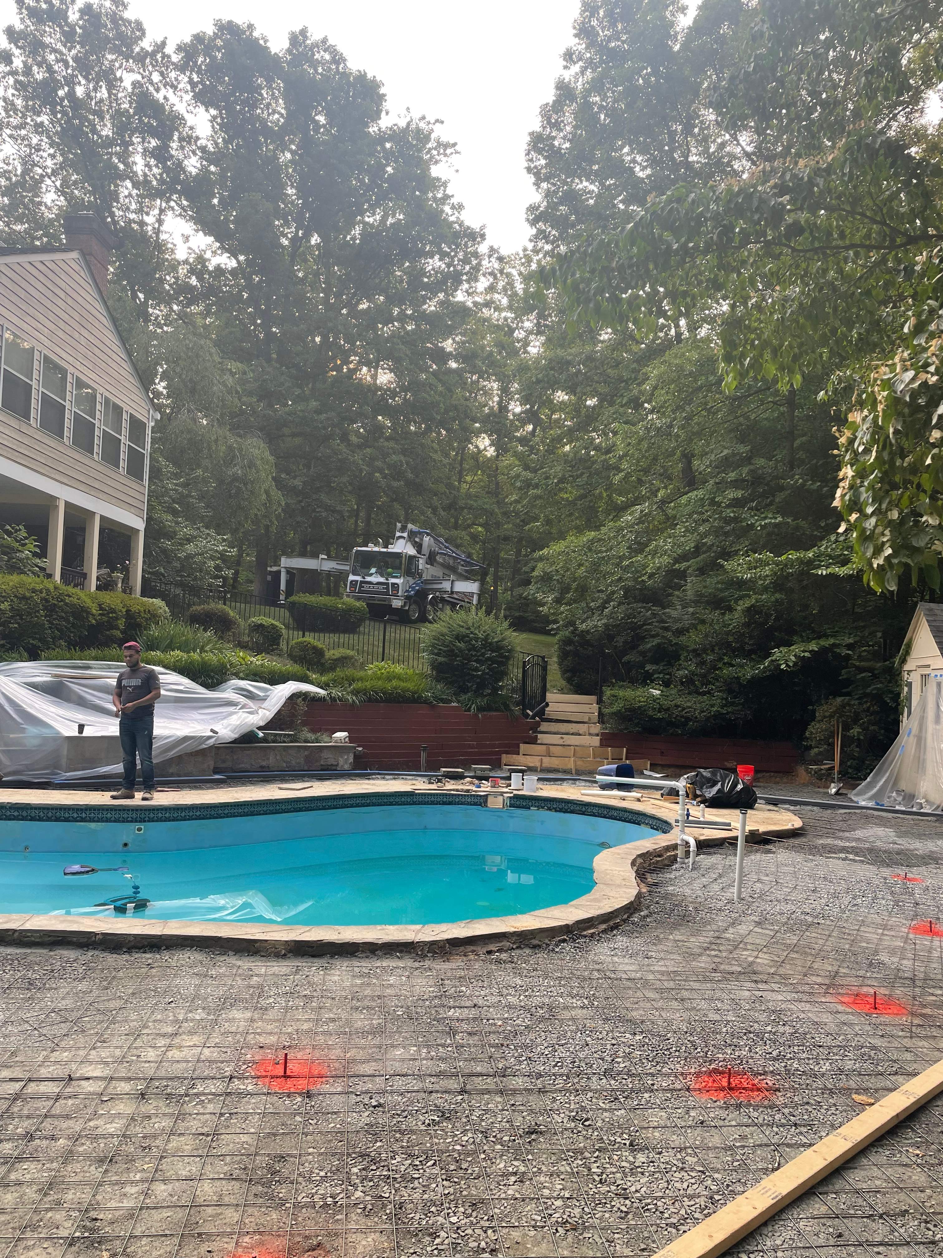 Pool Surround remodel with retaining walls, new waterfall and water slide by Fairfax Contractors, LLC