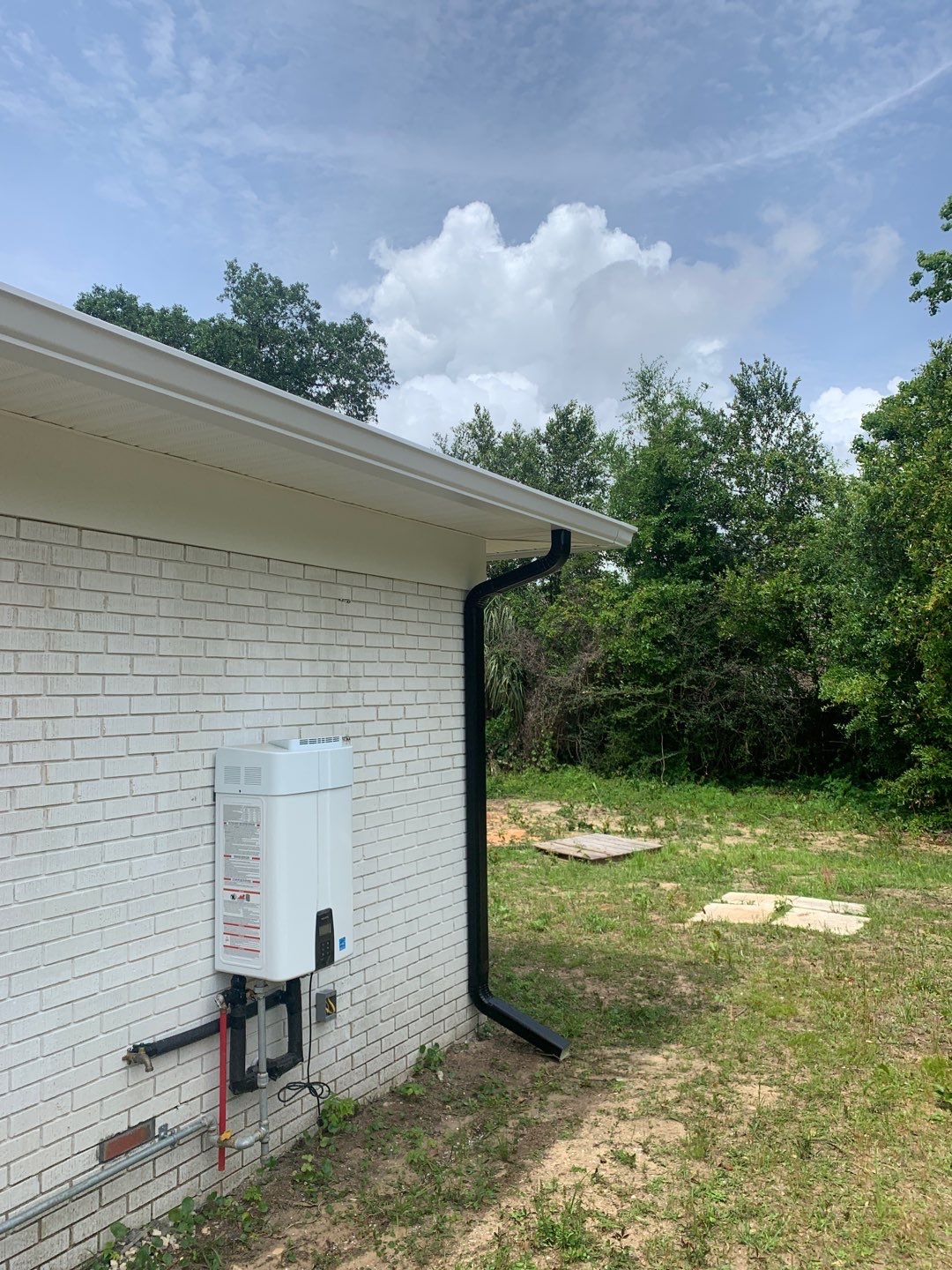 White Seamless Gutters and Black Downspouts by Gutter Professors