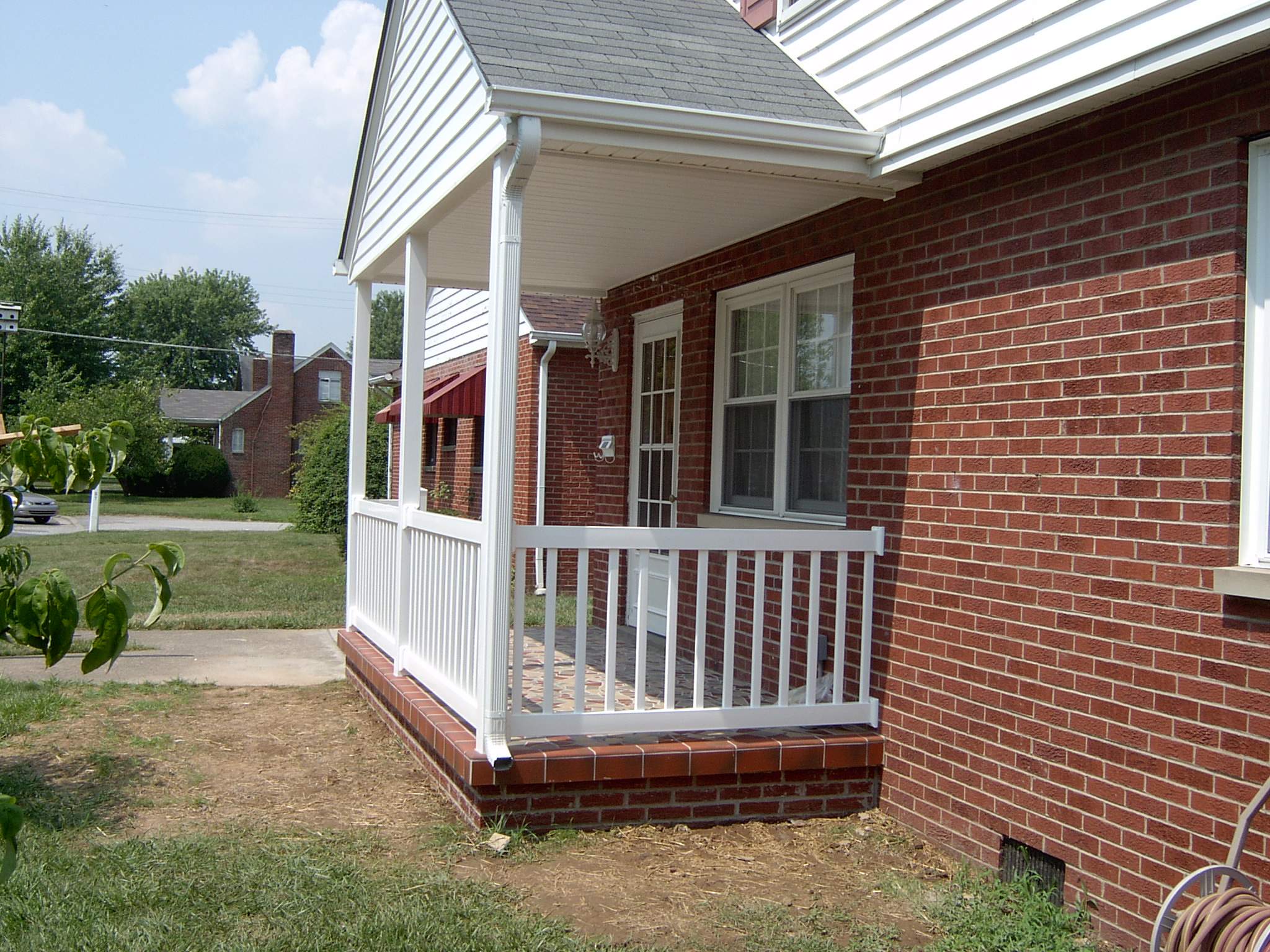 New front porch build, with tile floor and vinyl railing. by Secure Construction Company Inc