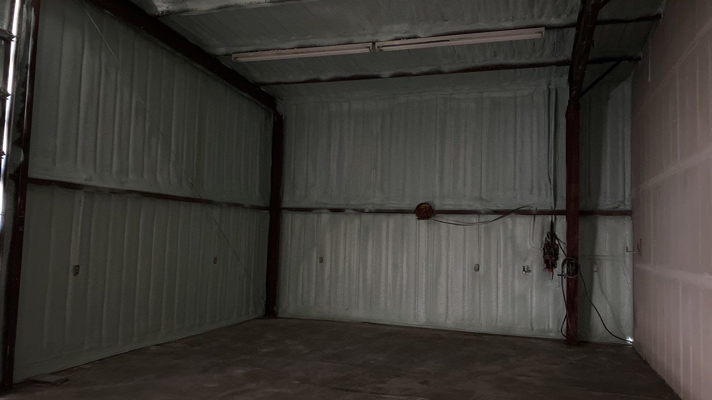 Spray foam insulation on inside of metal industrial building by Straight Edge Roofing Inc