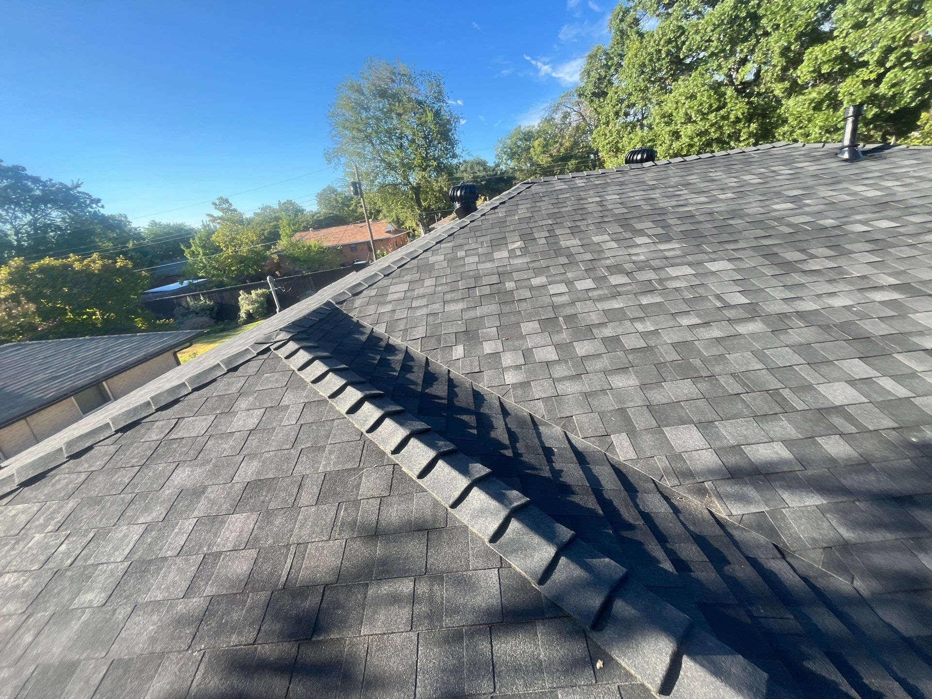 White brick/light gray shutters with IKO Granite Black  by Tejas Roofworks + Restoration