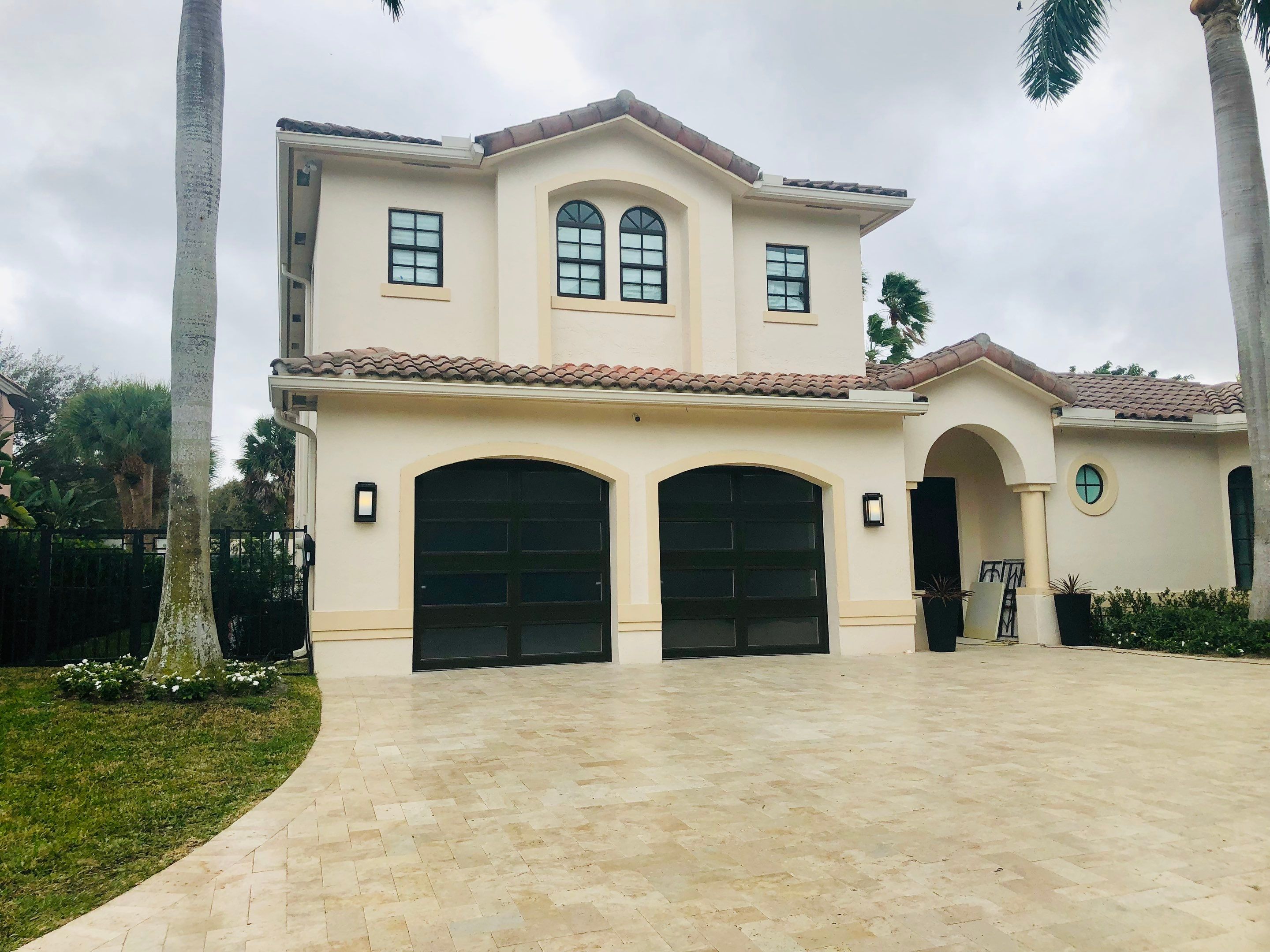 Modern Bronze Garage Door Installation With Frosted Glass in Boca Raton by The Door Doctor of South Florida, Inc.
