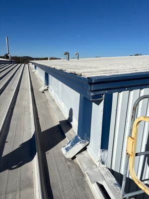 Metal roof edge with gutter and downspout installation