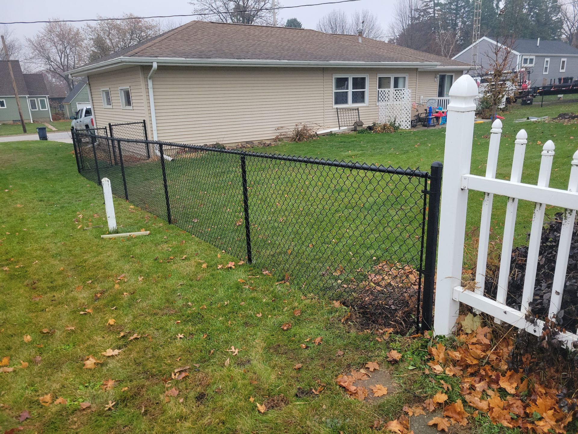 Black Vinyl-Coated Chain Link Fence Installation in Aplington by Perfect Picket Fence and Stain