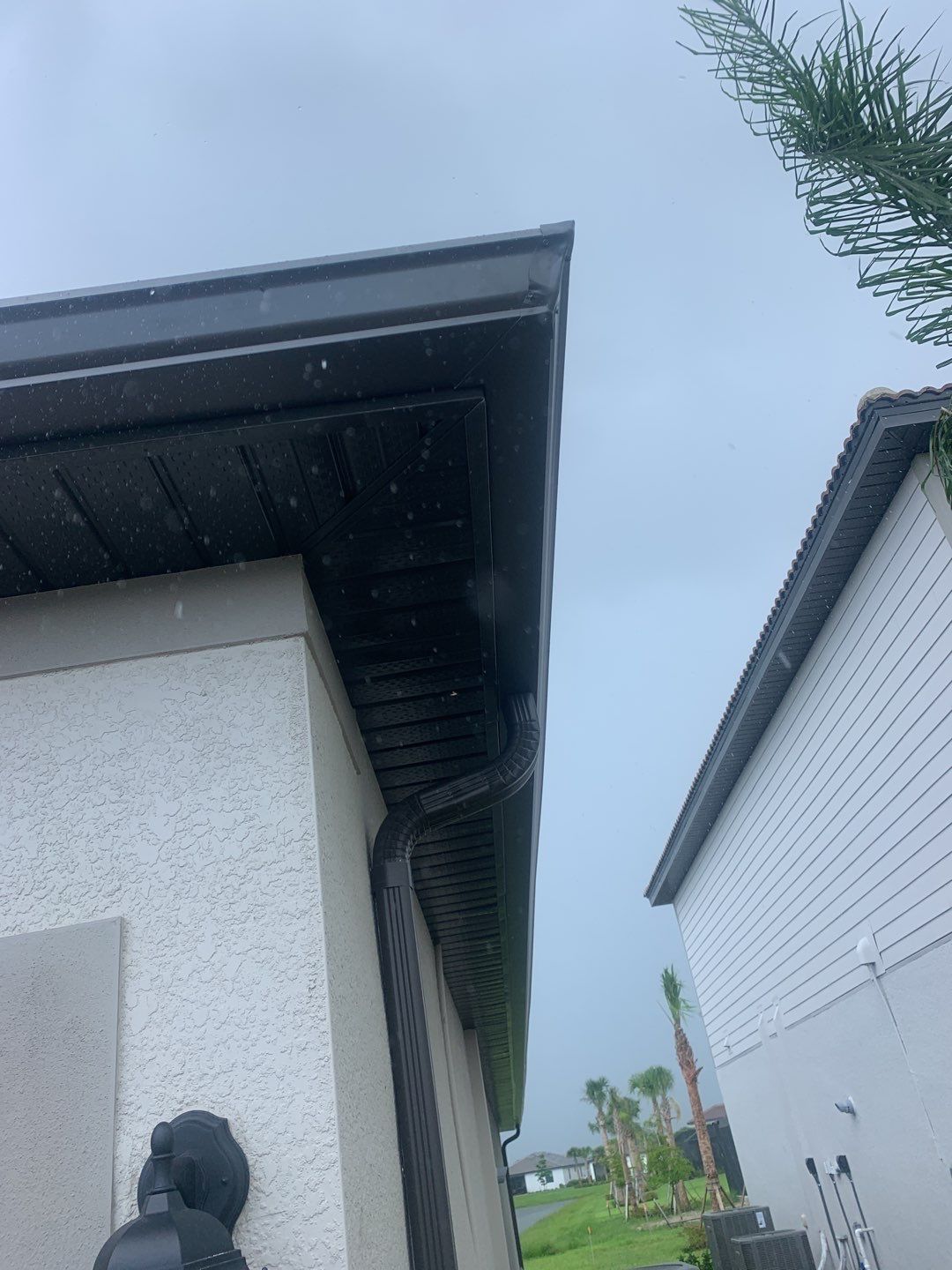 Seamless brown gutter and downspouts installation in Estero, FL  by Gutter Professors